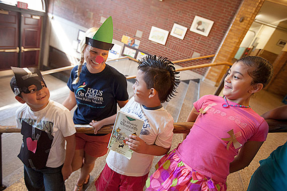 Student Denny Diaz, (from left) McKay School teacher, Brianna Guilford (green triangle hat), Andy Reyes, and Carol Cruz perform an activity based on the Wizard of Oz book read in class as part of the Pretext program inside the McKay School in East Boston. The program began at Harvard and has been implemented in Boston Public Schools' English Language Learners summer school programs. Kris Snibbe/Harvard Staff Photographer