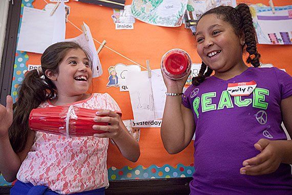 McKay School students Sarah Martinez (left) and Emily Depina use sounds and homemade instruments to interpret a passage they read in “The Little Prince.”