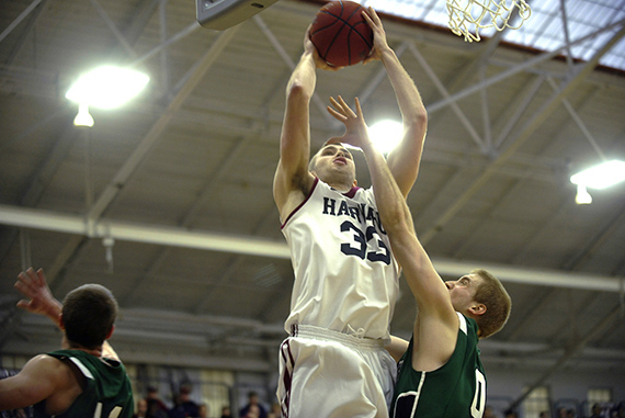 Crimson forward Evan Cummins '16 goes strong to the hoop over a Big Green defender. Cummins scored 8 points off the bench.