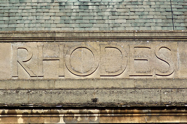 The photo of the embossed stone sign that reads Rhodes was taken at the back of the Rhodes House, the headquarters of the Rhodes Scholarships and the Rhodes Trust.
