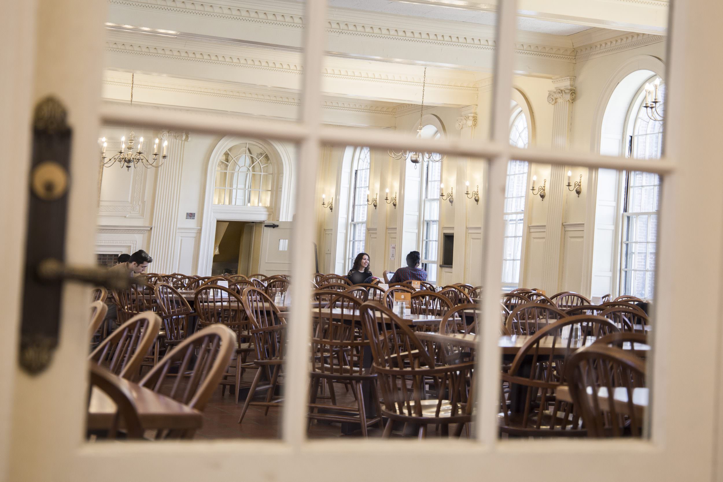 Looking through a glass door at Kirkland House dining hall.