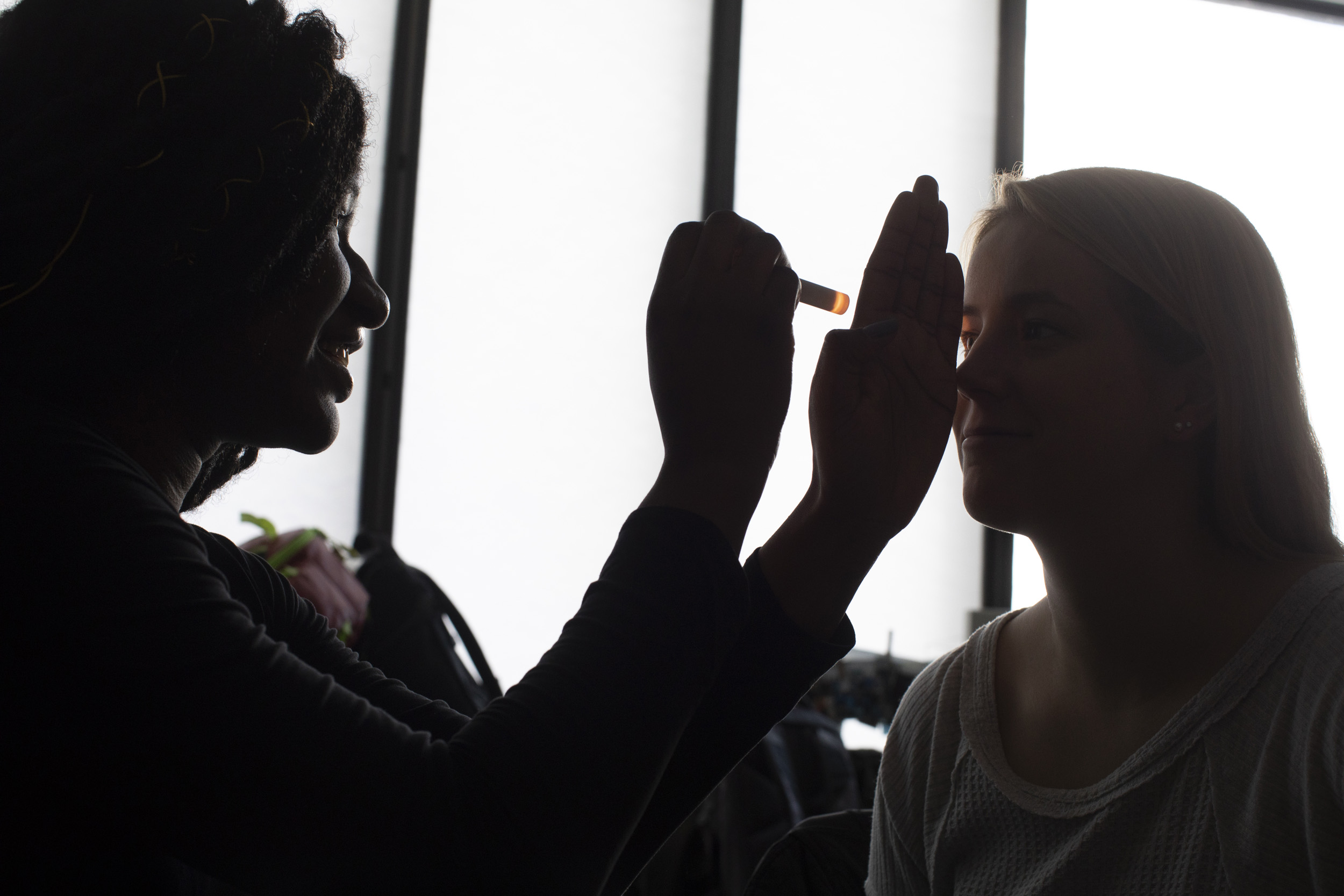 Silhouetted against a window, students check each other’s pupils for dilation.