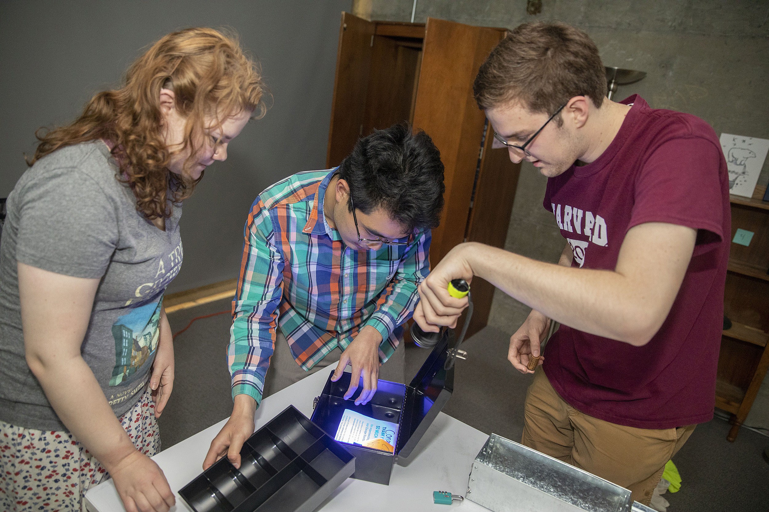 Jena Lorman (left), Michael Cheng, and Tyler Morris solve puzzles in a sustainability-themed "escape room."