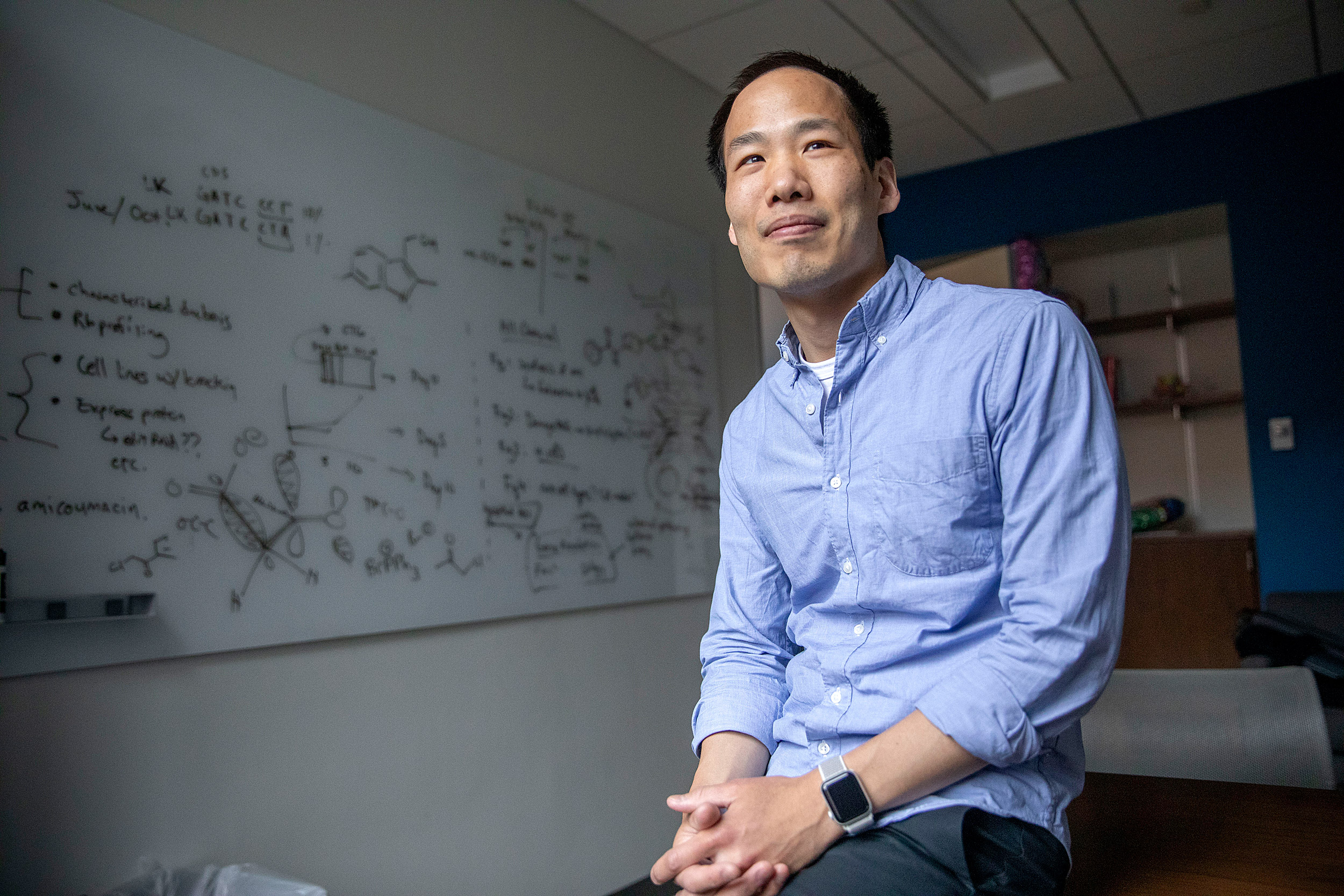 Professor sits in front of a white board