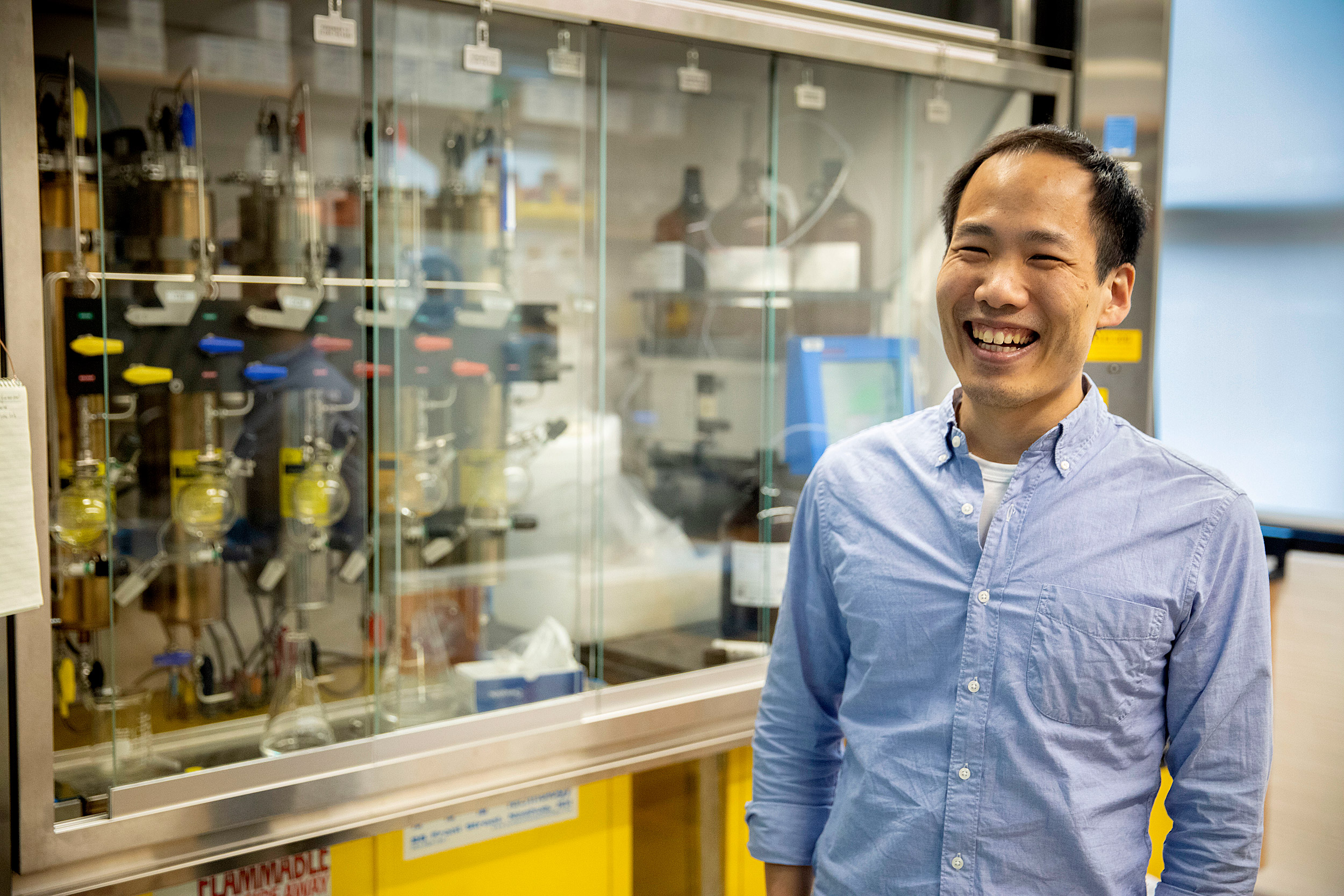 Professor smiles in front of lab equipment