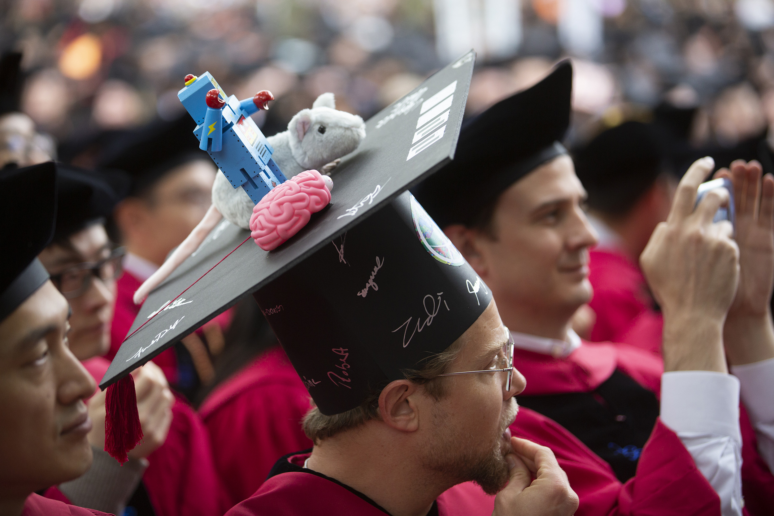 Daniel Haehn wears a cap decorated with a toy robot, mouse, and brain.