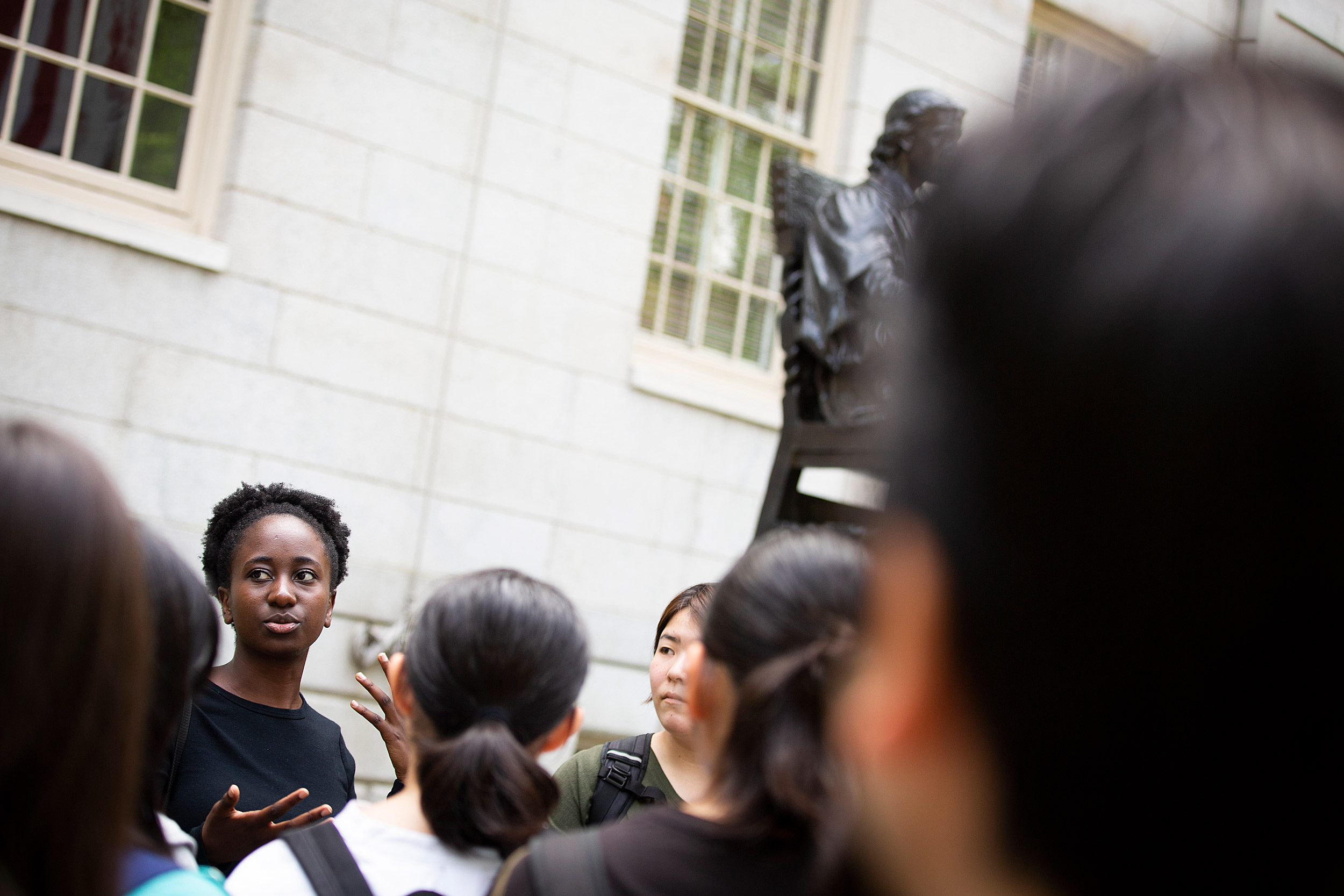 Sammota Mwakalobo leads a tour group by the statue.