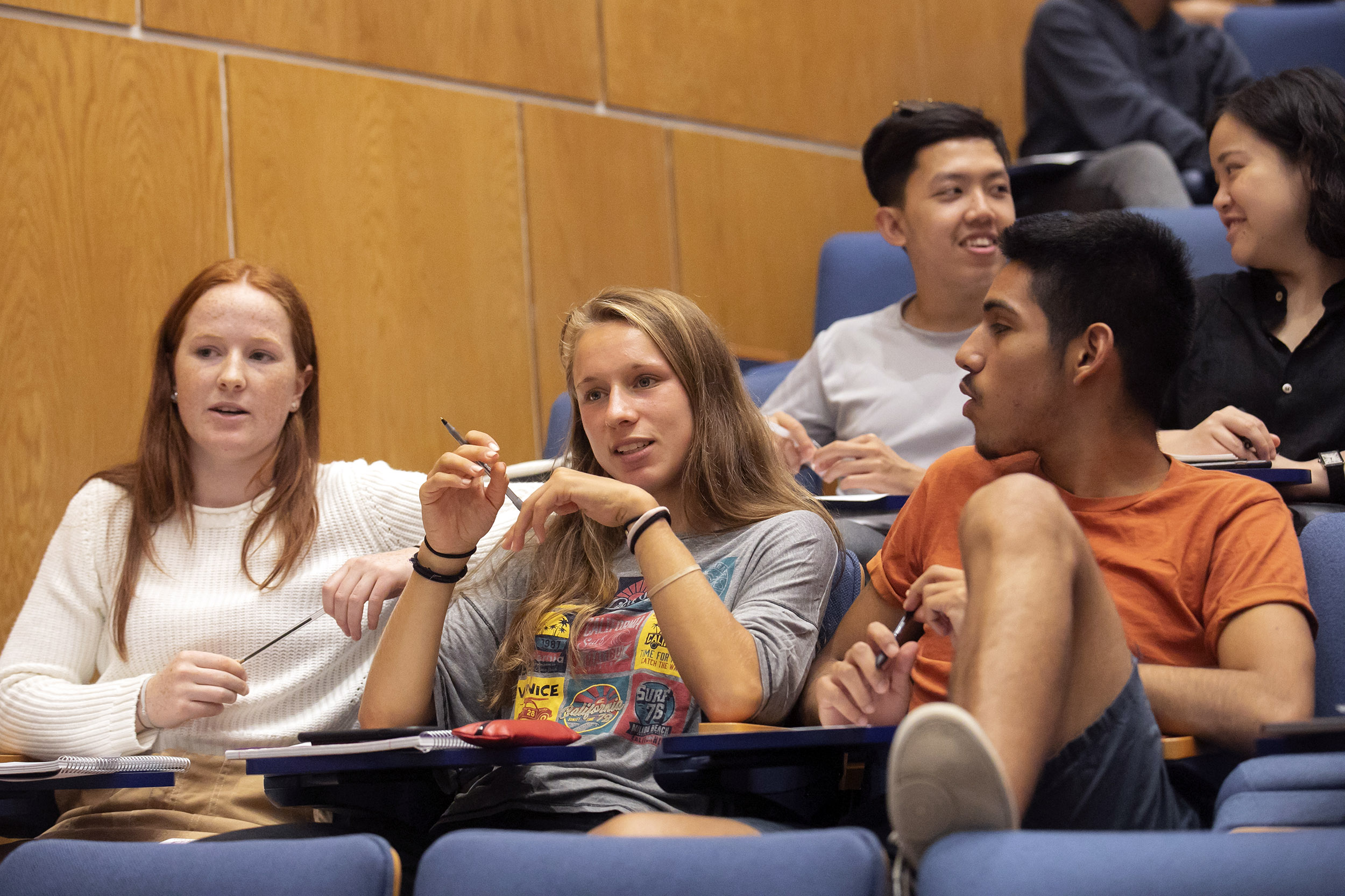 Three students speak during class.