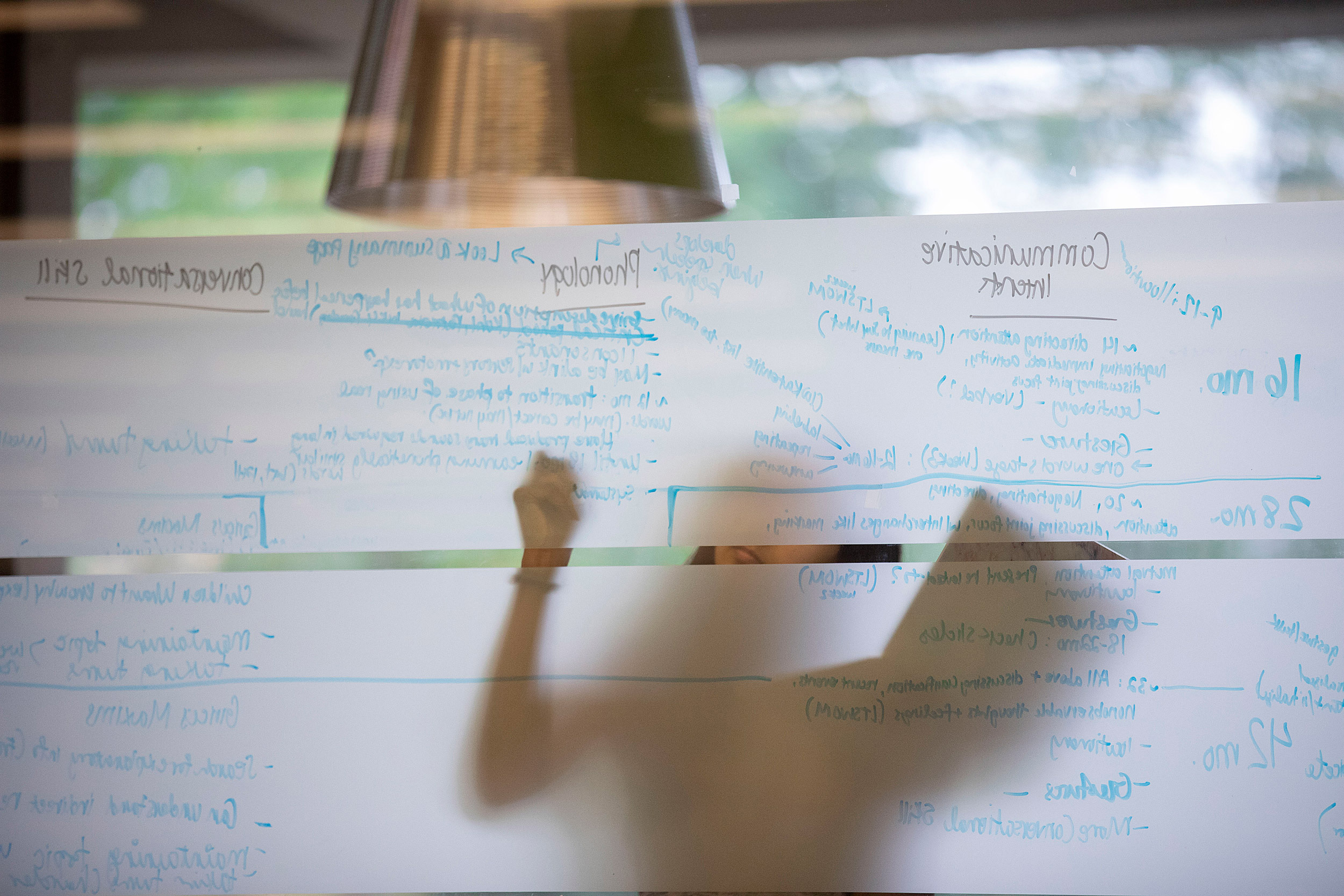 A student writing her homework assignment on a window pane.