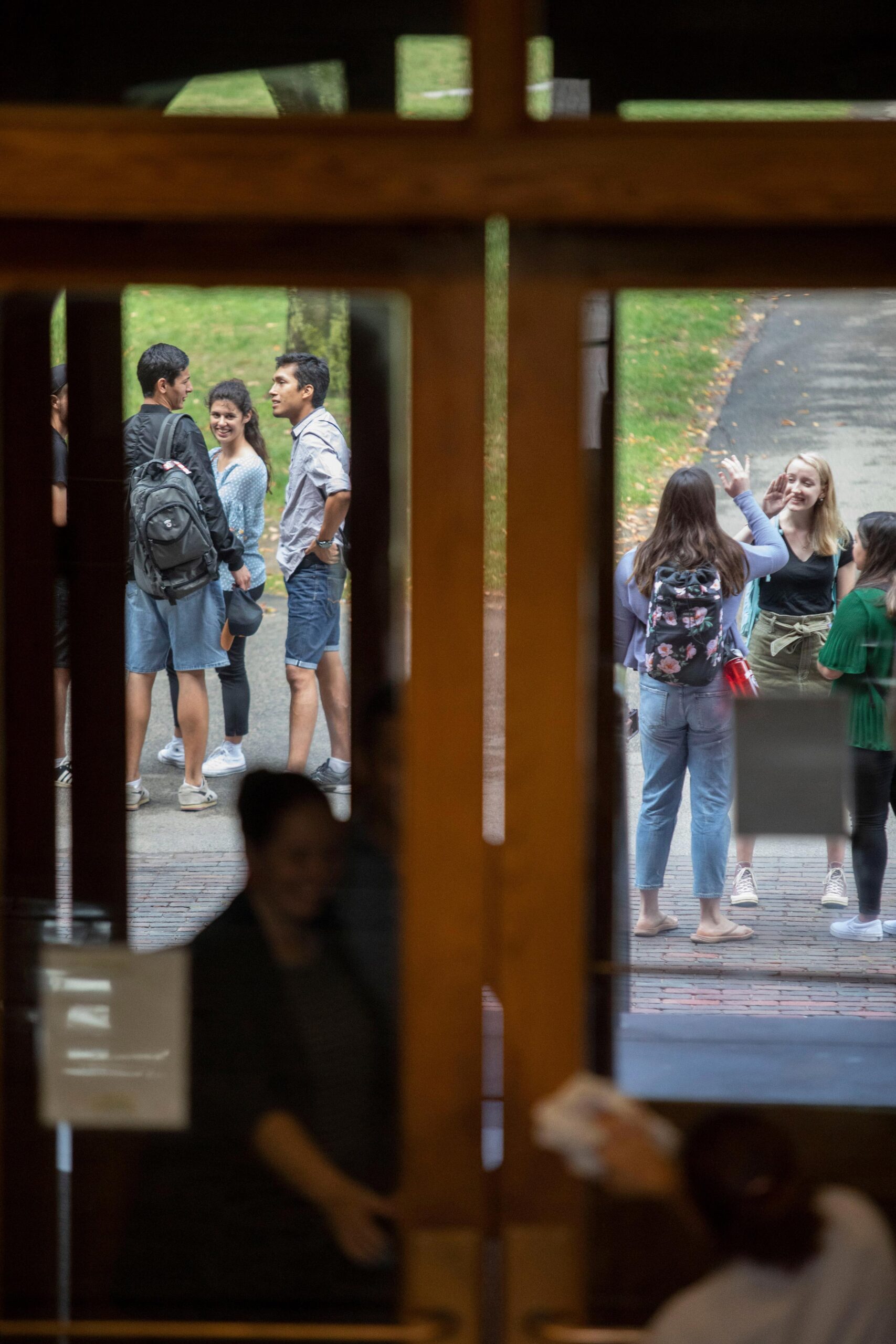 Cleaning crew washing doors, looking out at students.