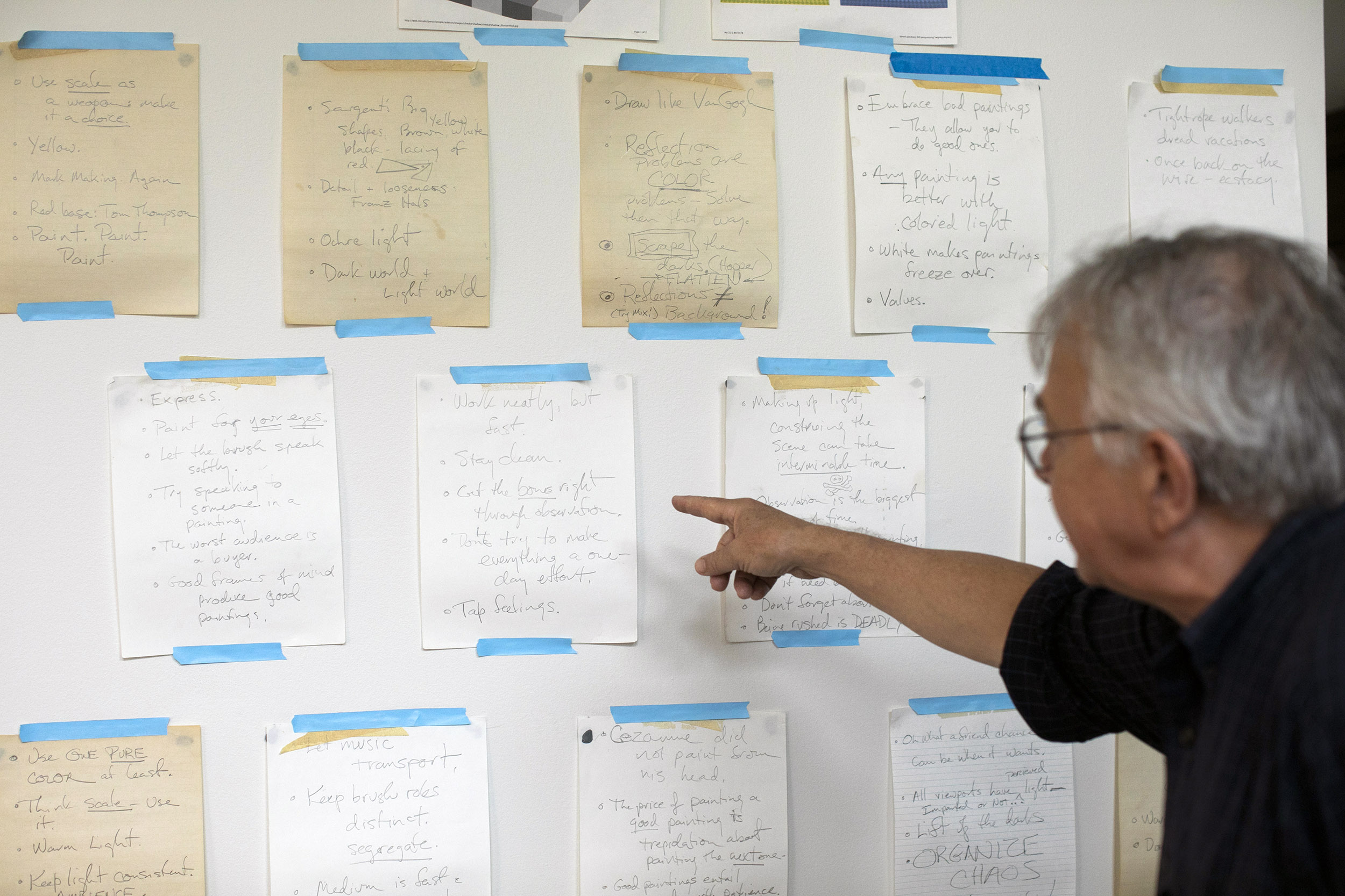 Stephen Coit points to an array of helpful and inspiration notes taped to his studio wall.