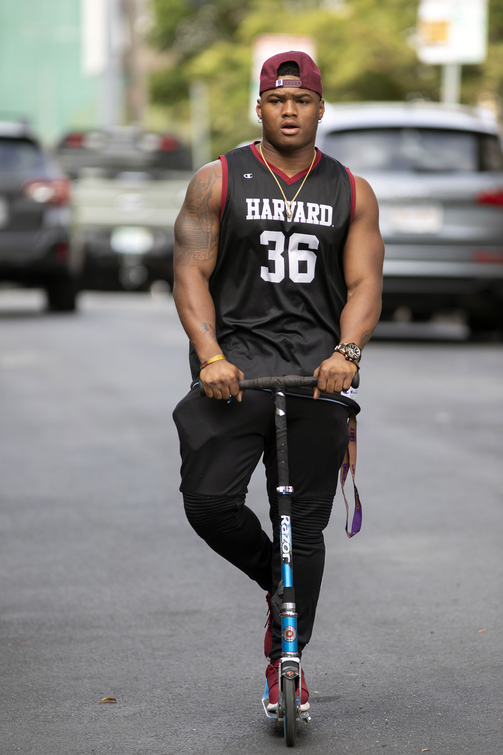 Devin Darrington rides a razor scooter to practice near Kirkland House.