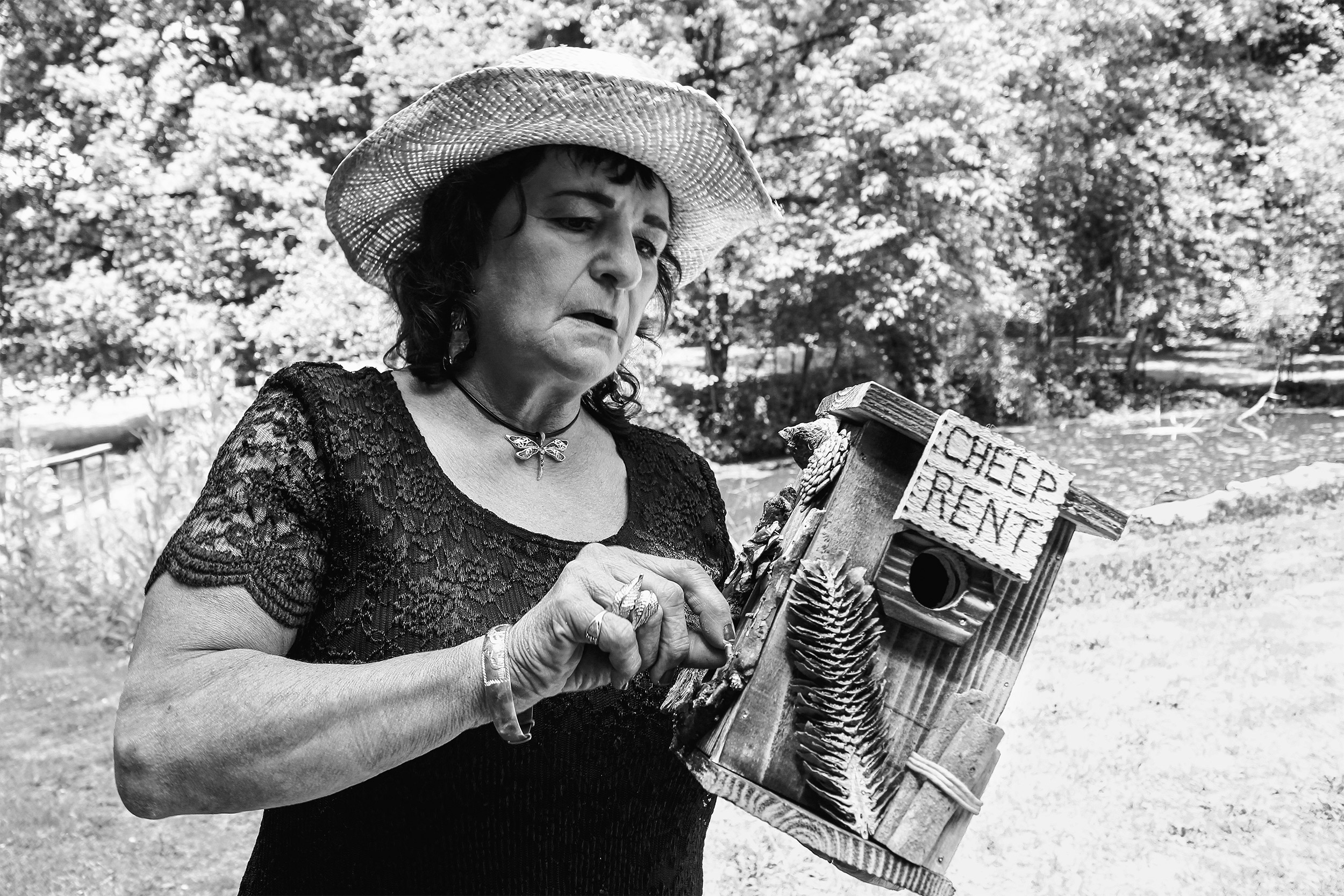 Woman with birdhouse that says "Cheep Rent."