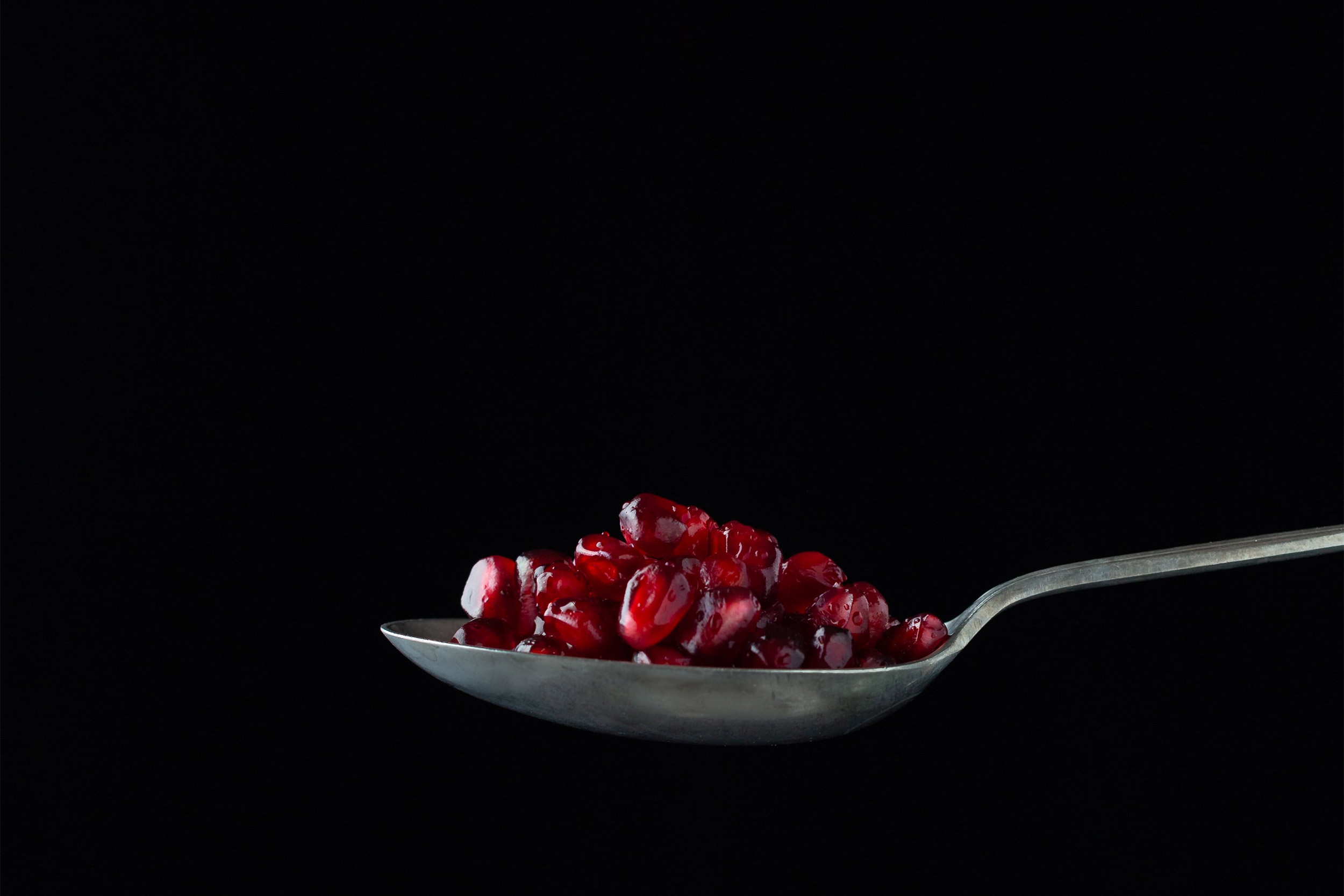 Spoon with pomogranate seeds.