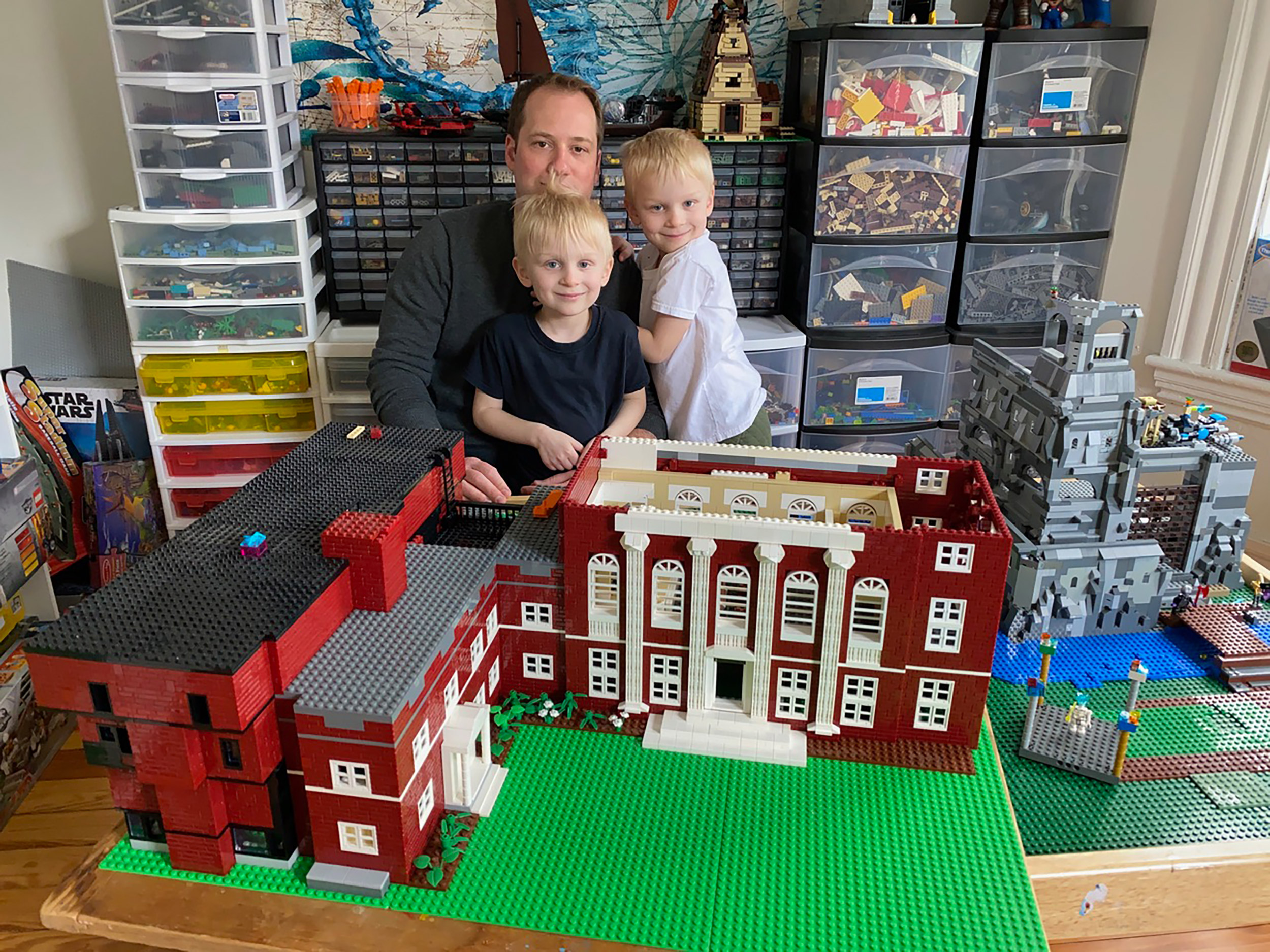 Jonathan Savilonis and sons Julius and Lysander with their LEGO model of Harvard's Music Building.