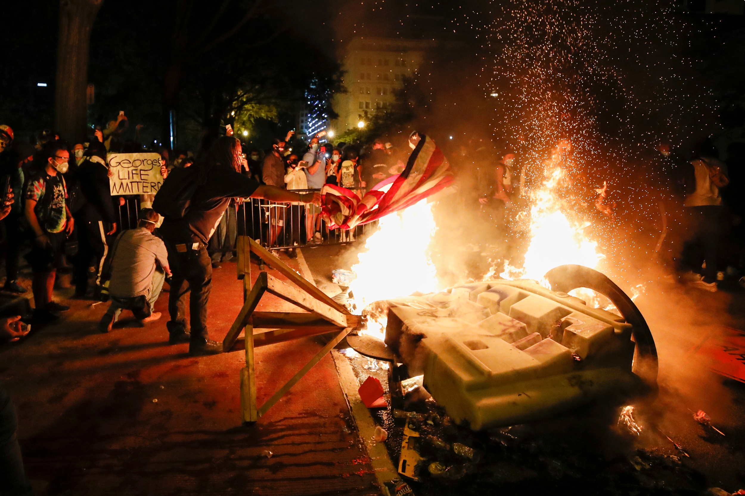 Fire burns during protest of police killing of George Floyd outside White House.