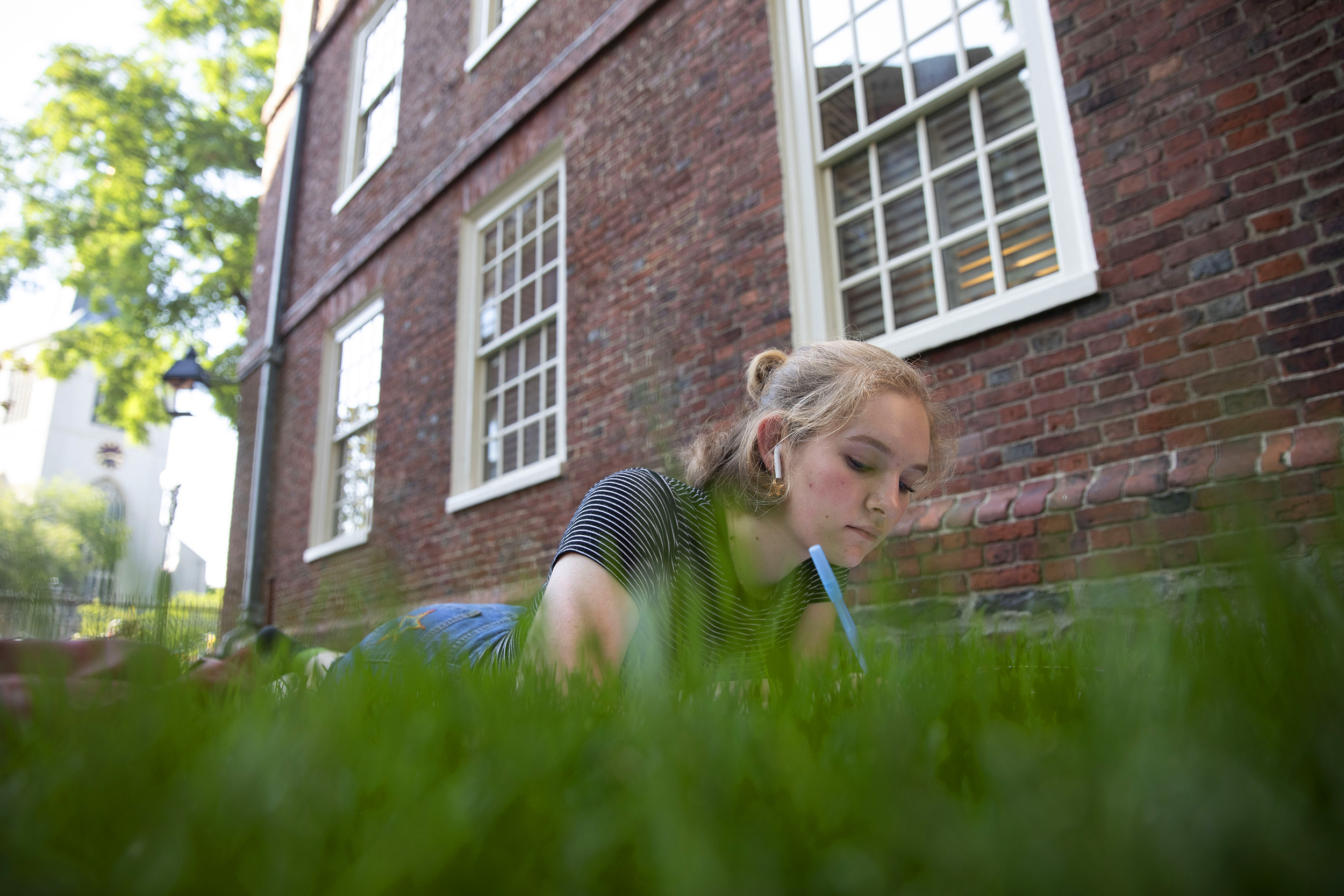 Behind Massachusetts Hall, Grace Carlson ’23 enjoys an 80-degree fall day.