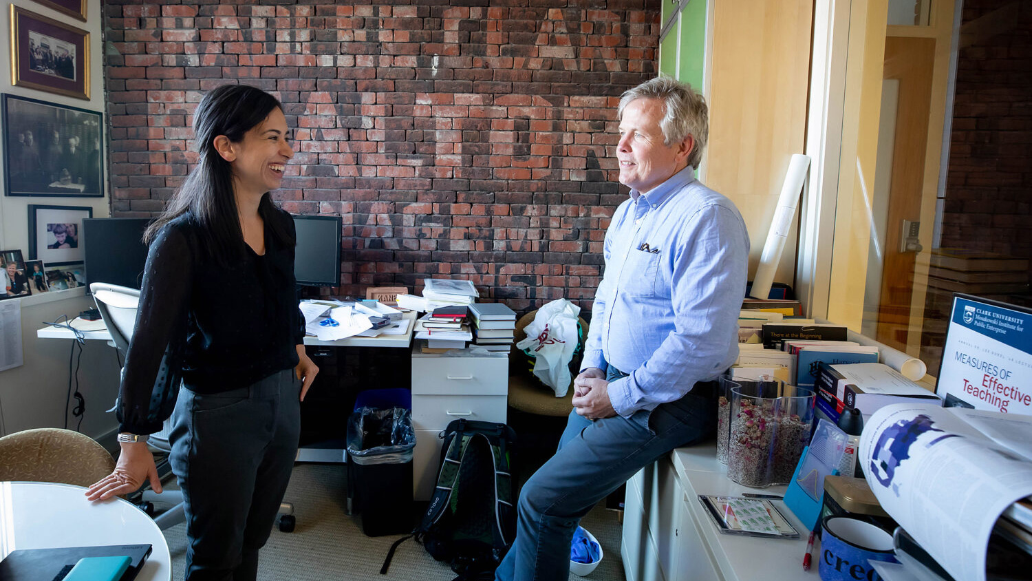 Thomas Kane and Jennifer Ash talking to each other in the office