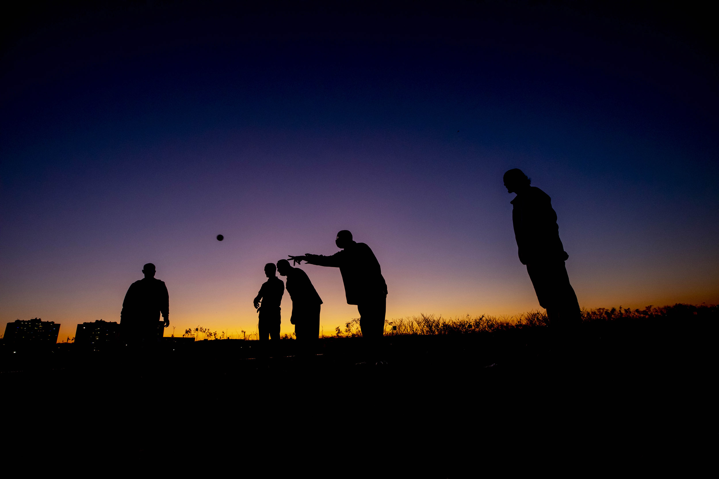 Playing Pentanque, a bocce-like game.