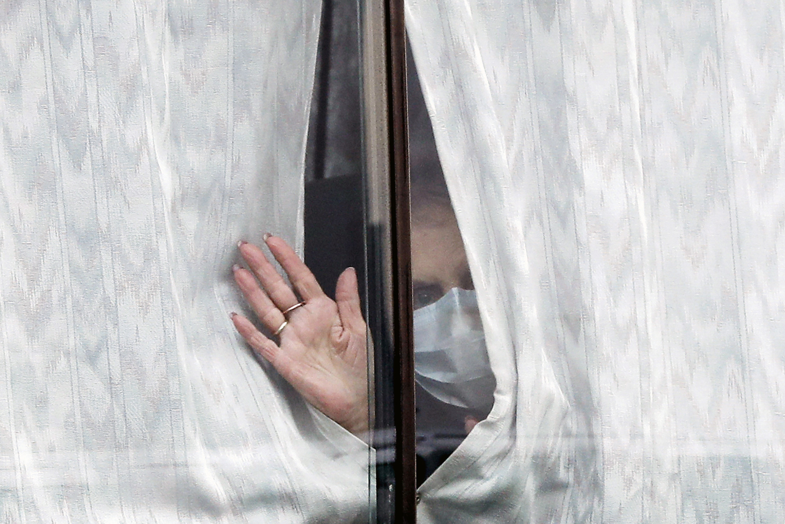 A woman waves from a window.