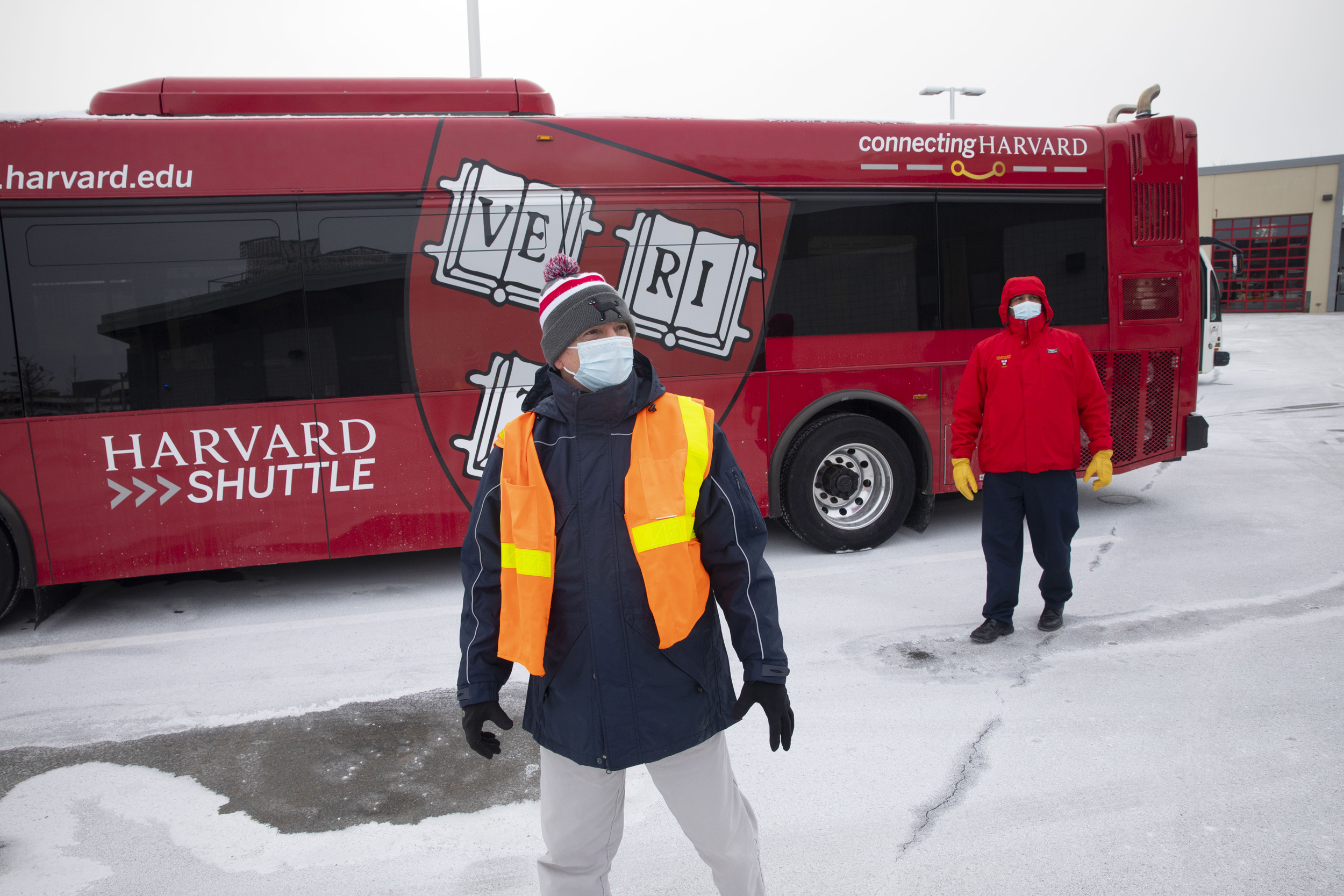 Two Harvard transportation people with bus.