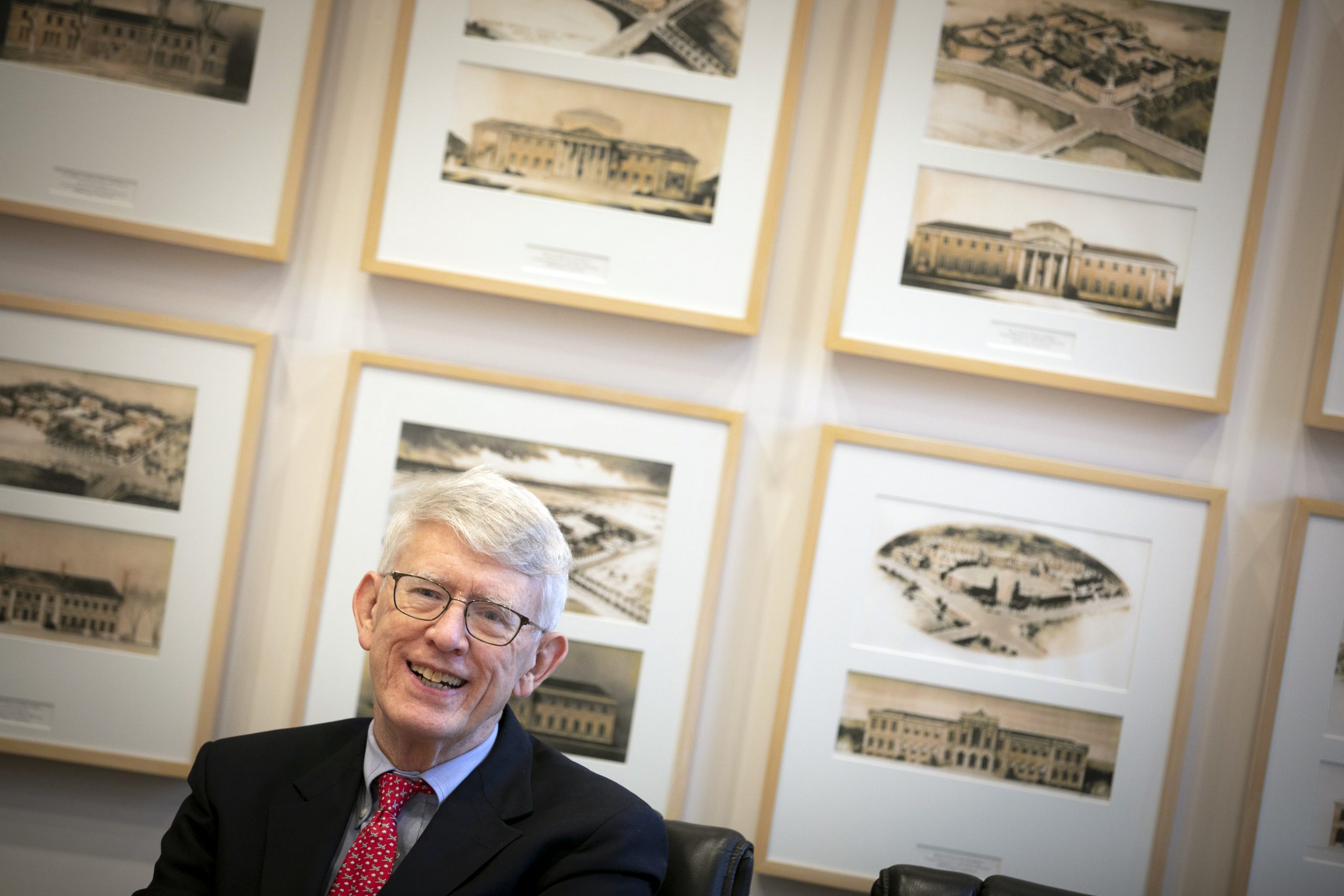 Tom Glynn in front of framed paintings