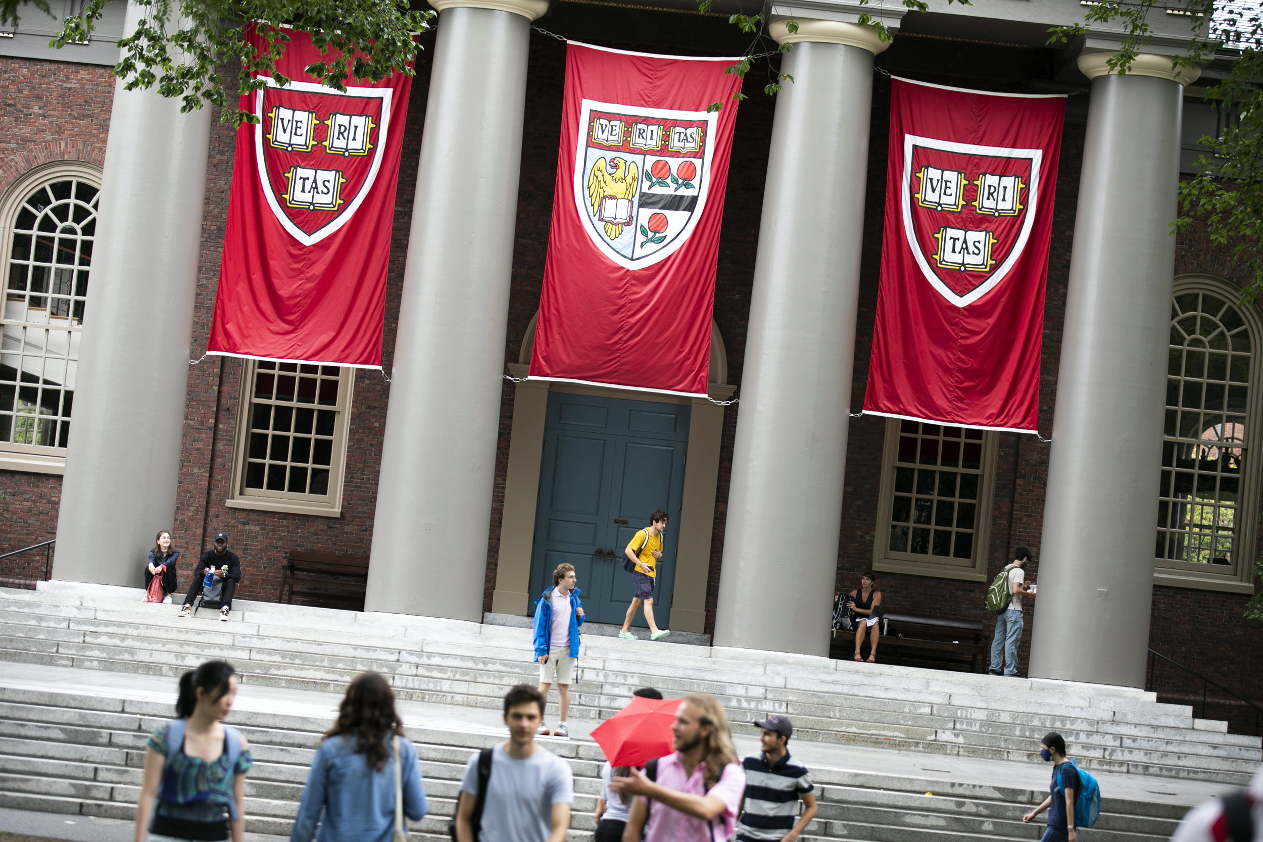 People walk past Memorial Church under three veritas banners.