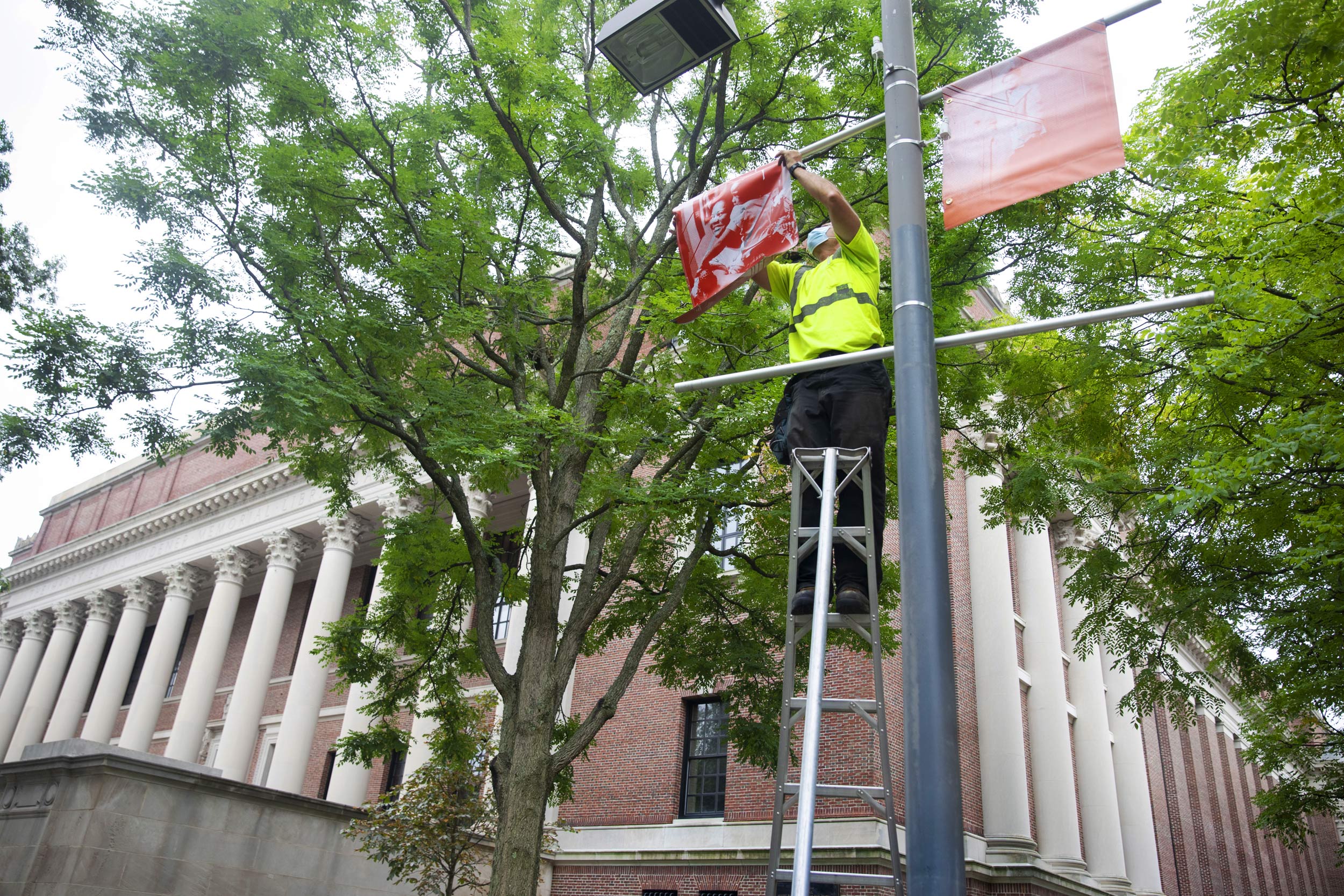 Mark Muniz of Harvard Campus Services installs banners.