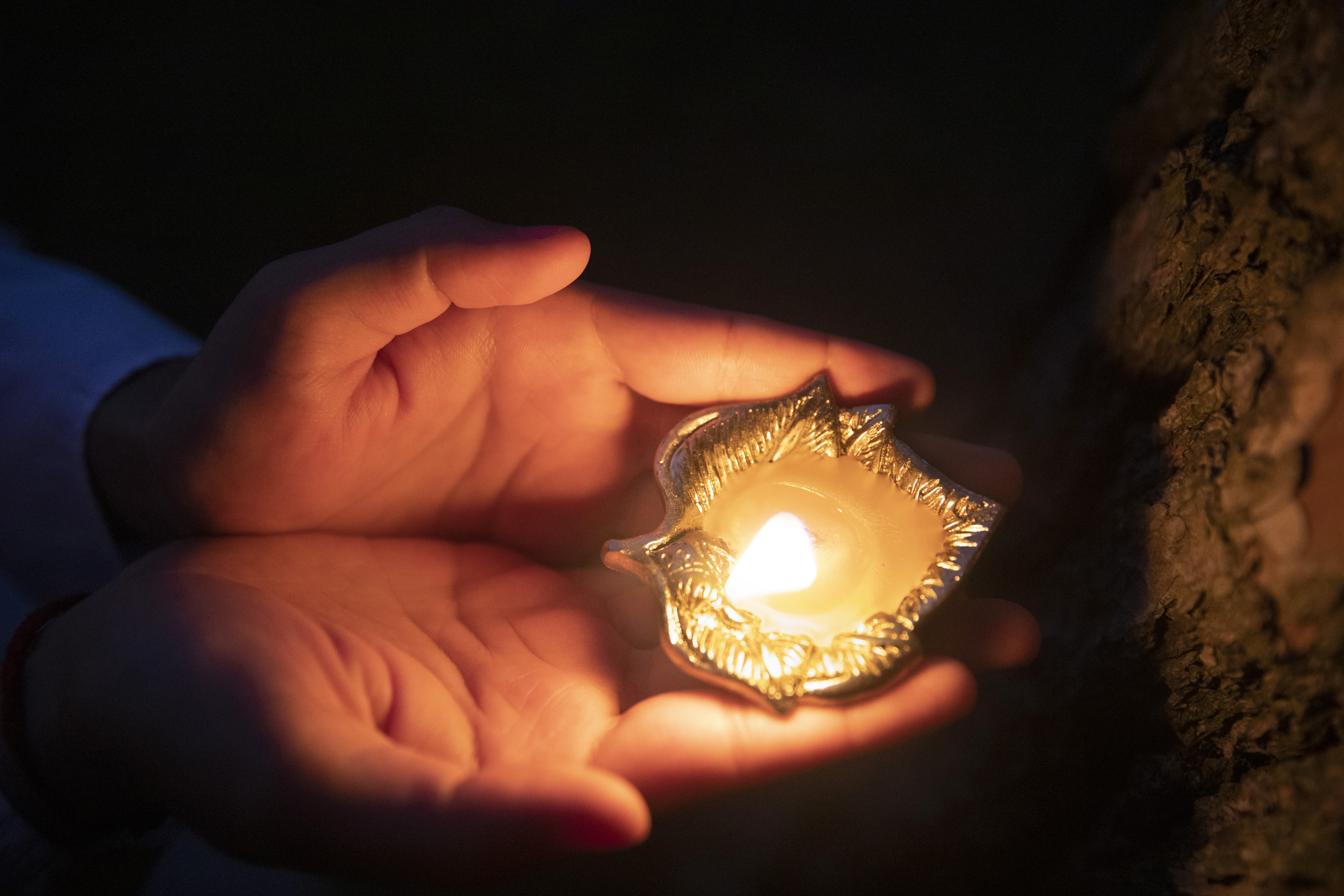 (Venerable) Vandan Sadhak, HDS student and Hindu monastic celebrates Diwali at dusk outside Swartz Hall.