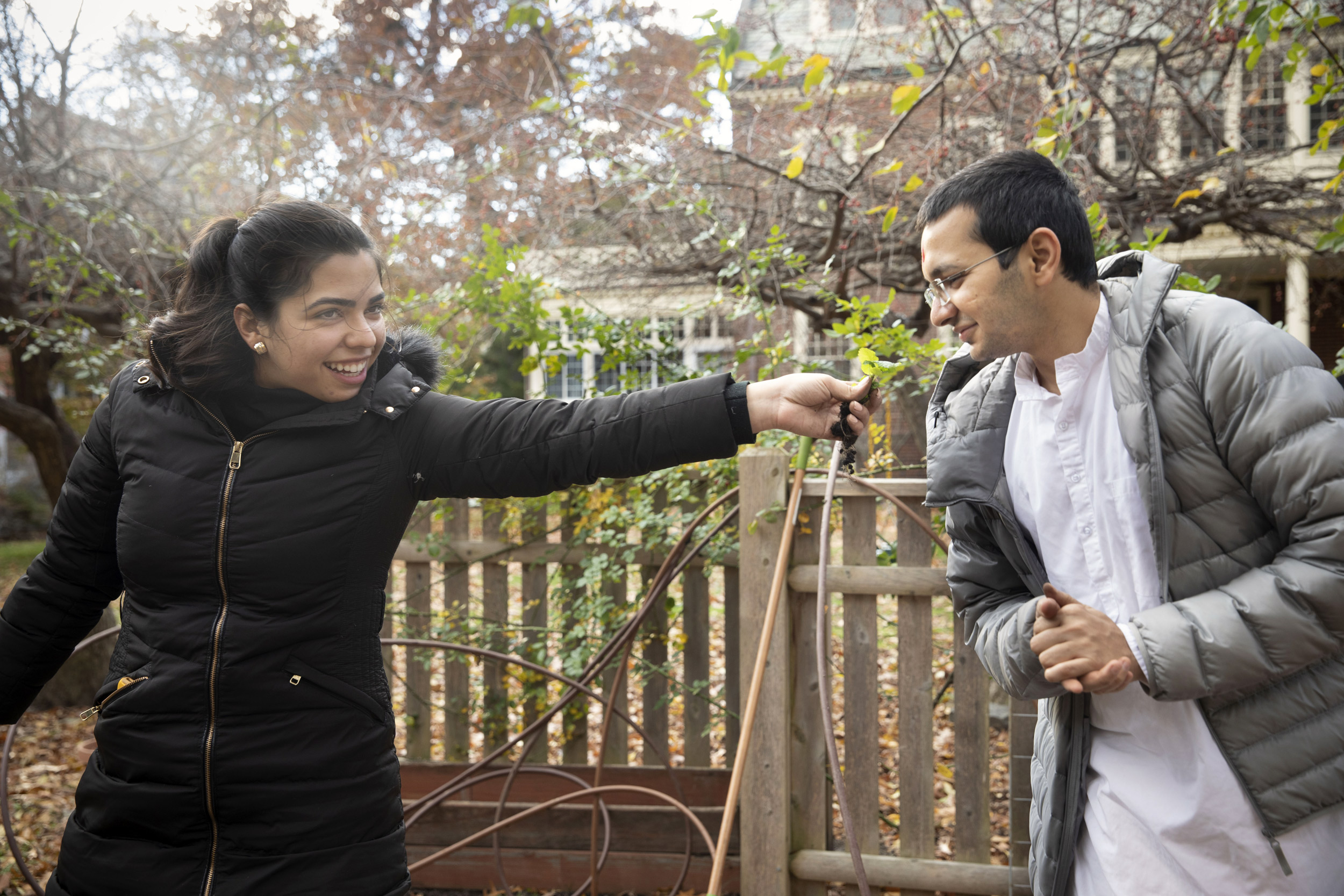 Sadhak and another Divinity School student, Melina Sotiriou Droz (left), smell fresh herbs.