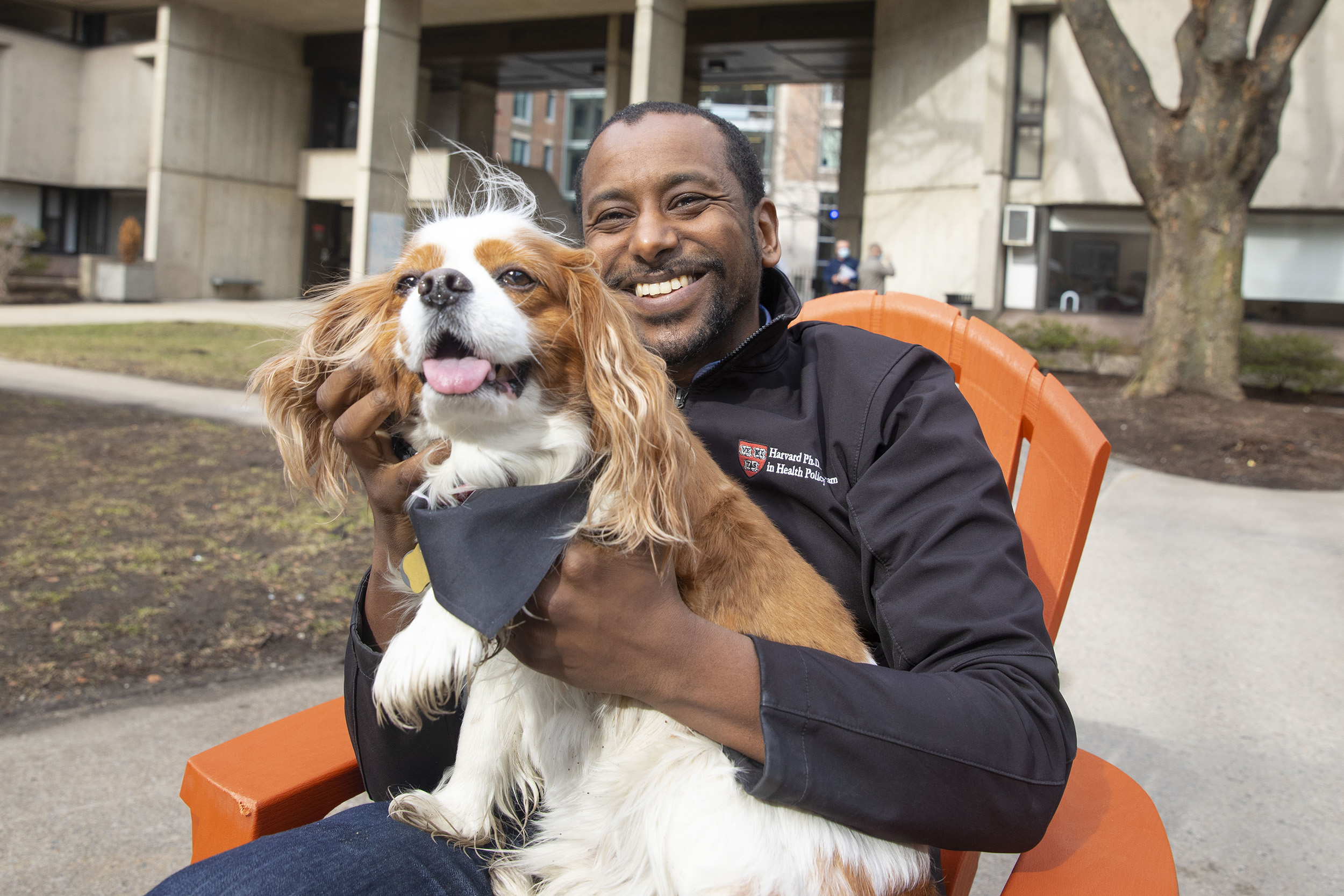 Anas El Turabi holds his cavalier King Charles spaniel Corgi in front of Mather House.