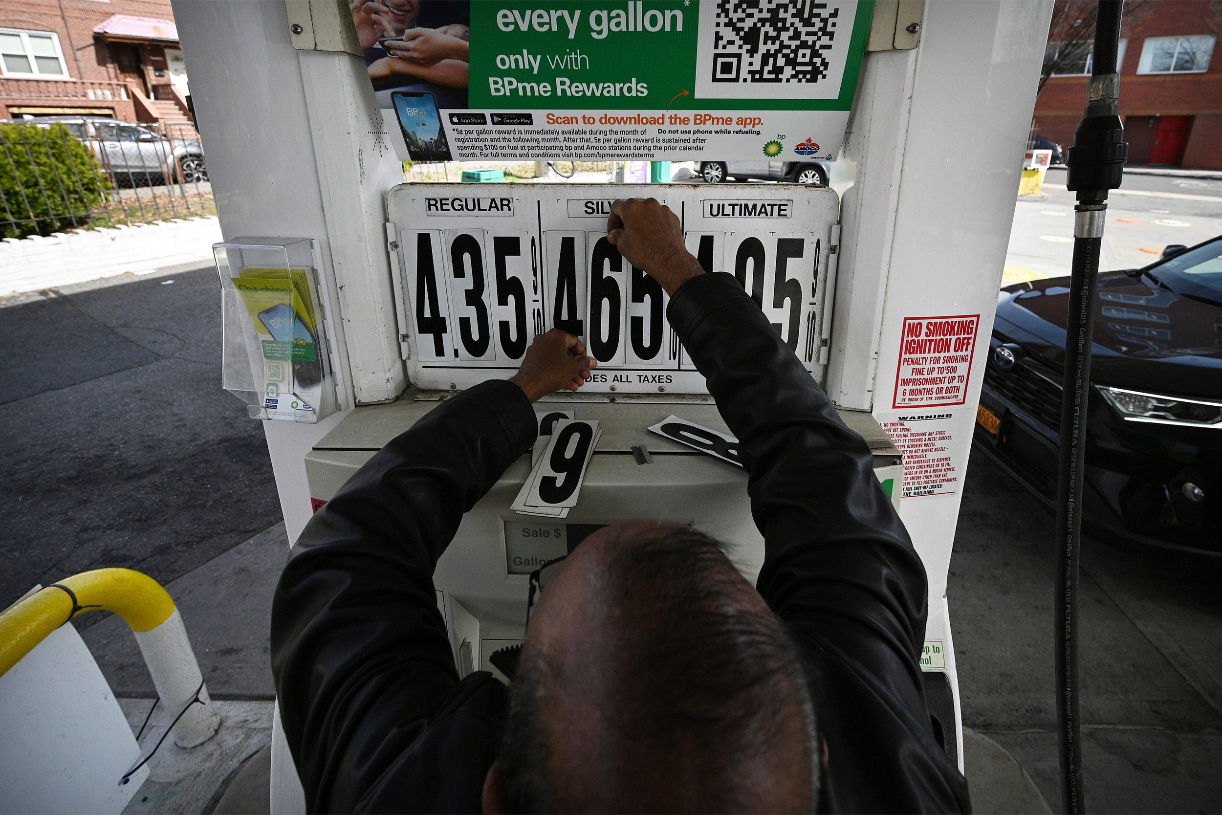 Man updated gas prices on pumps.