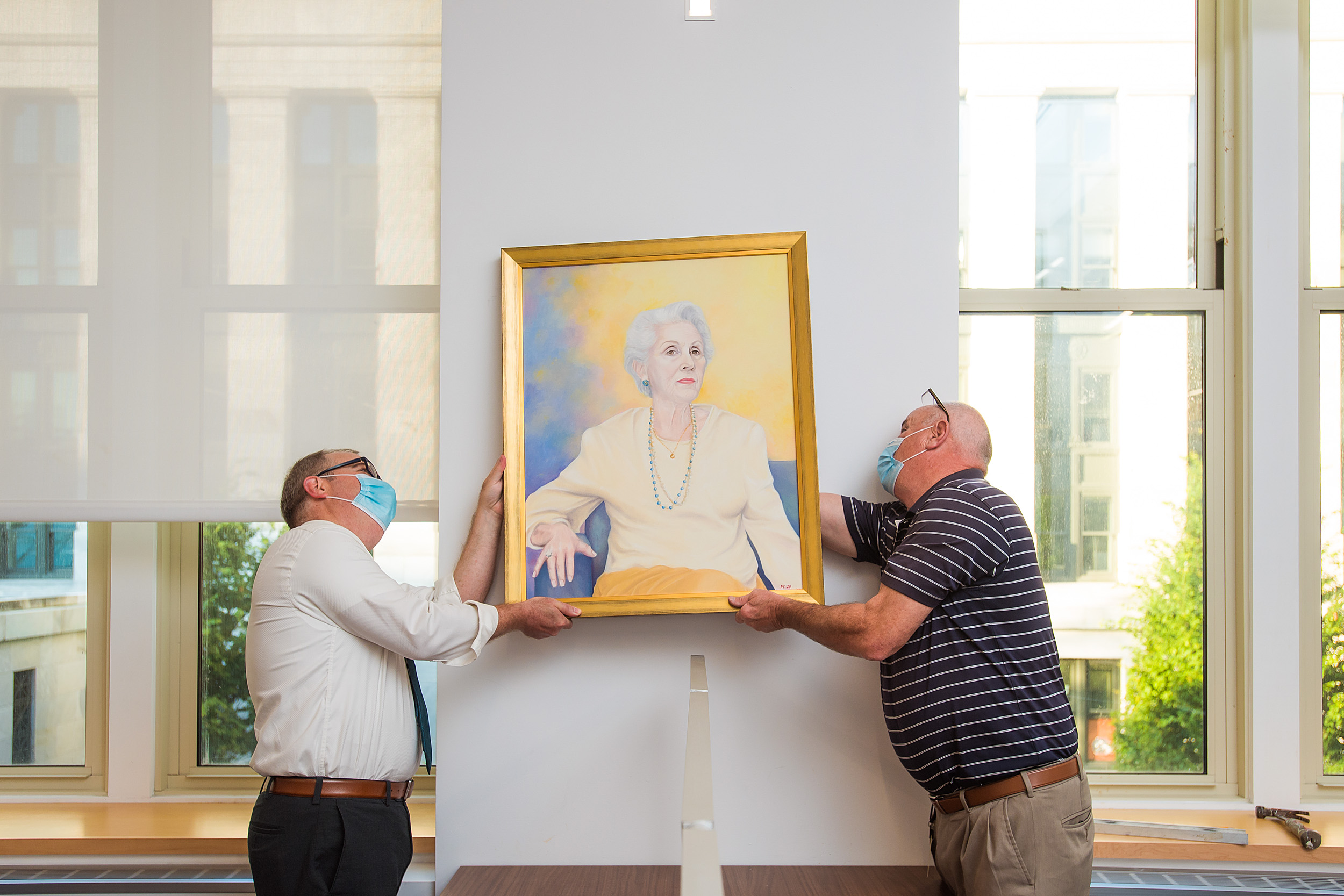 People hanging a painting.