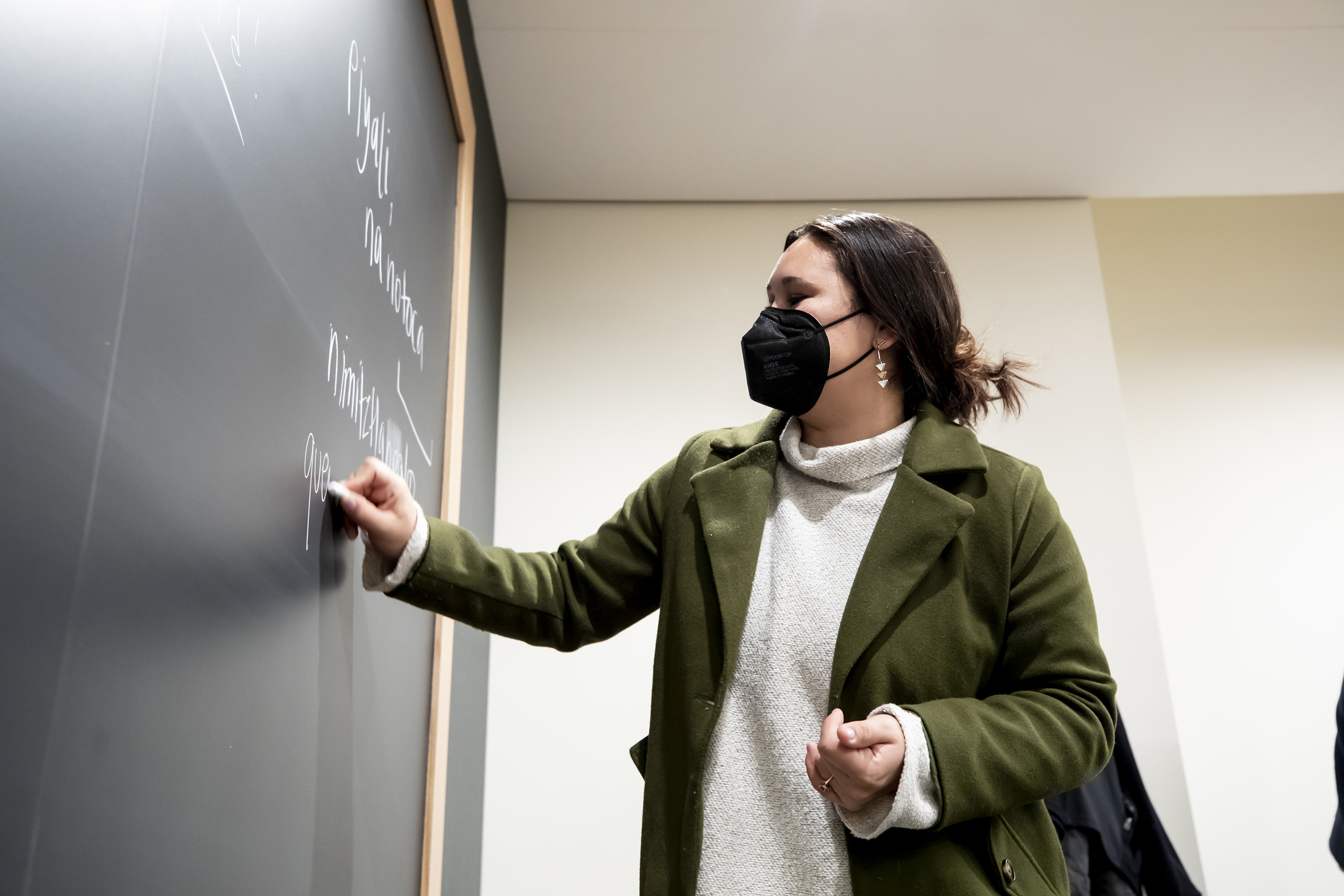 Rebecca Mendoza Nunziato writes in Nahuatl on blackboard.