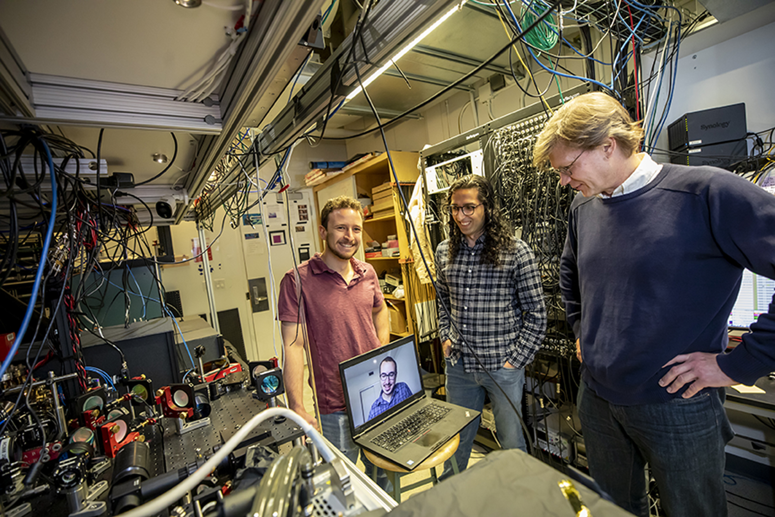 Dolev Bluvstein, Harry Levine (on the laptop), Sepehr Ebadi and Mikhail Lukin, on right, standing next to their neutral atom