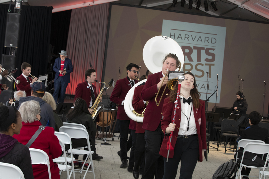 A marching band walking through a crowd