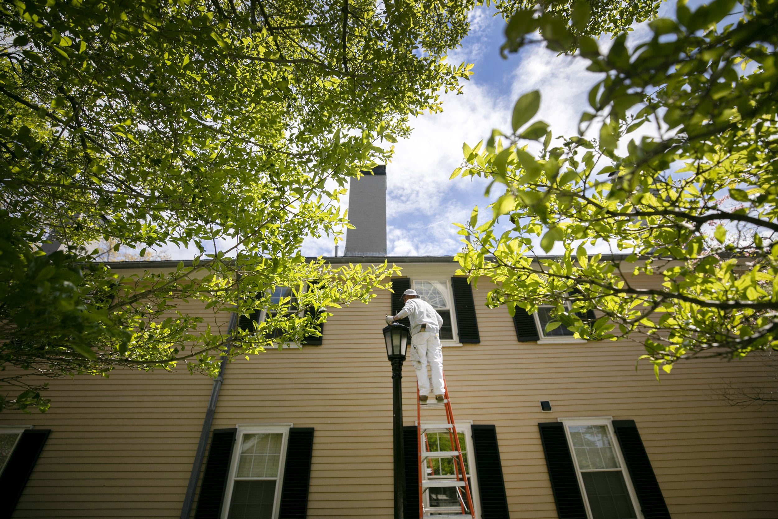 John Griffin paints and restores a lamppost alongside Buckingham House in Radcliffe Yard.