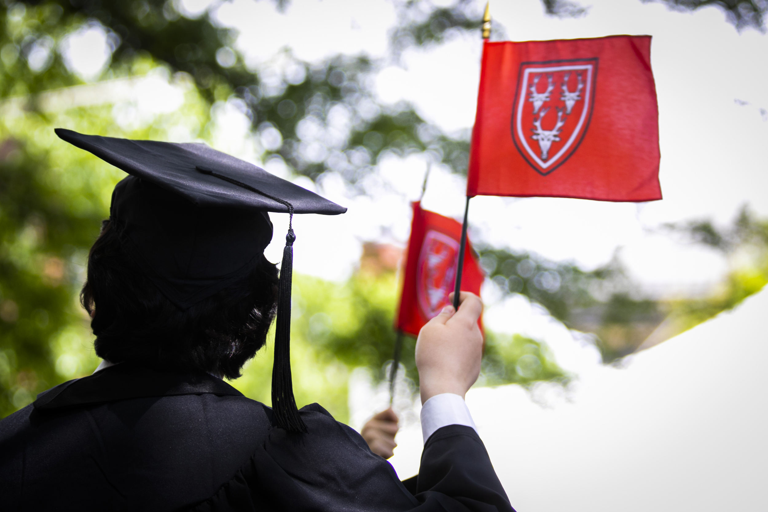 A student waves a Dunster House flag during the ceremony.