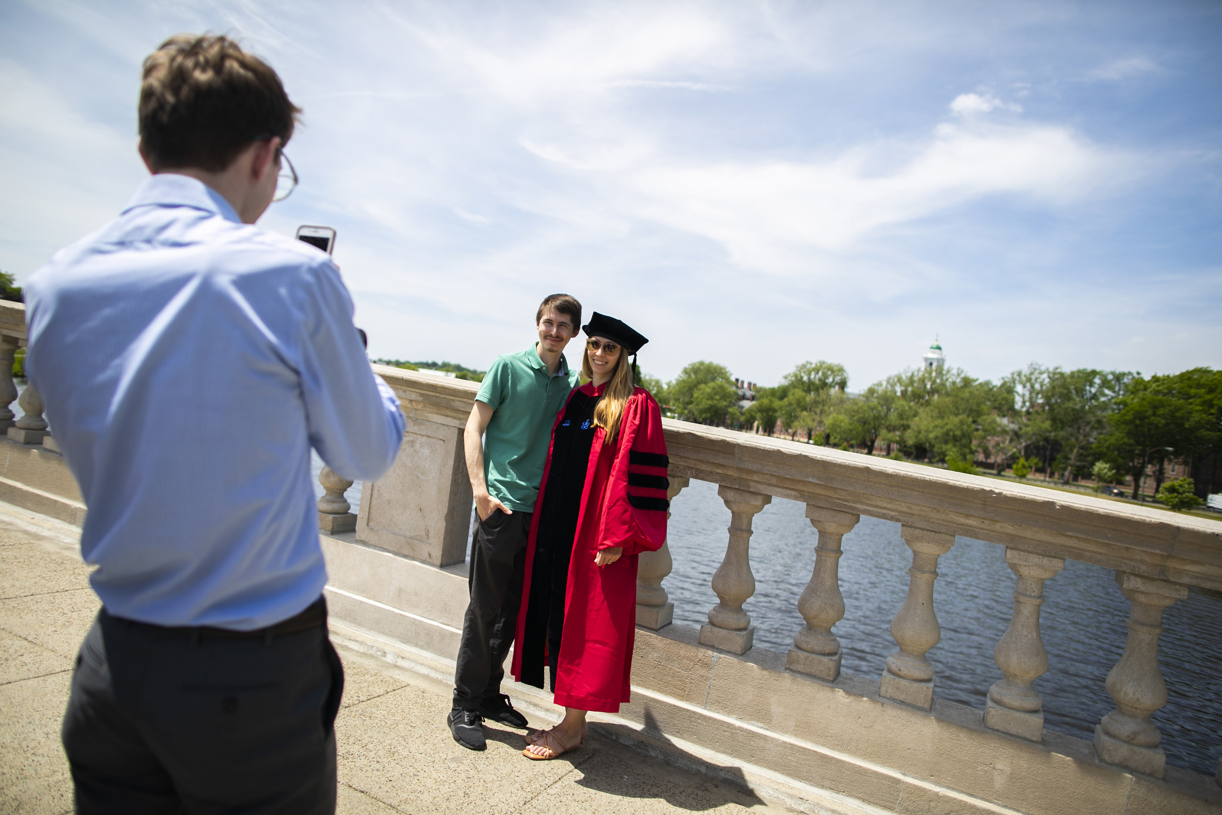 Brianna Duncan-Lowey (right), who graduated with a Ph.D. in virology, is pictured with her brother, Colin, on the Weeks Footbridge following the Morning Exercises.