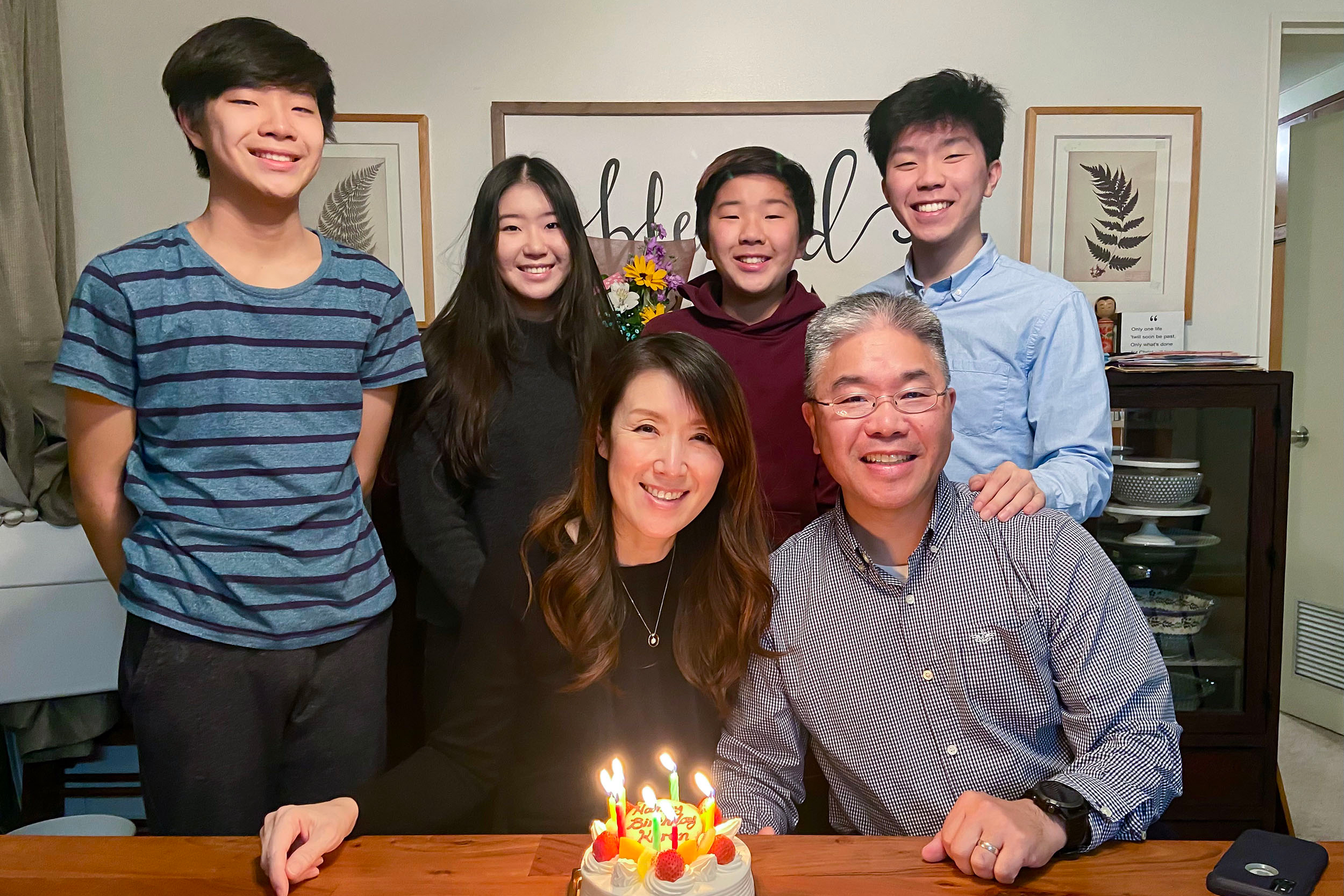 Elijah Suh, his siblings, and parents pose in front of birthday cake.