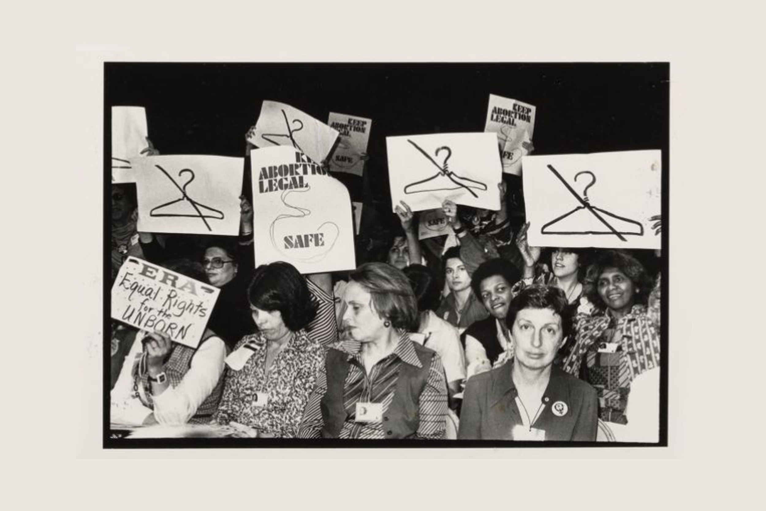 Women hold signs at International Women's Year conference in 1977.