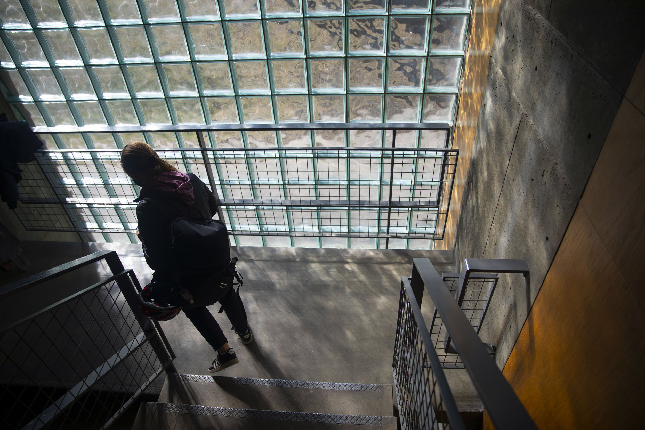 A person walks past the glass cube windows at Carpenter Center for the Visual Arts.