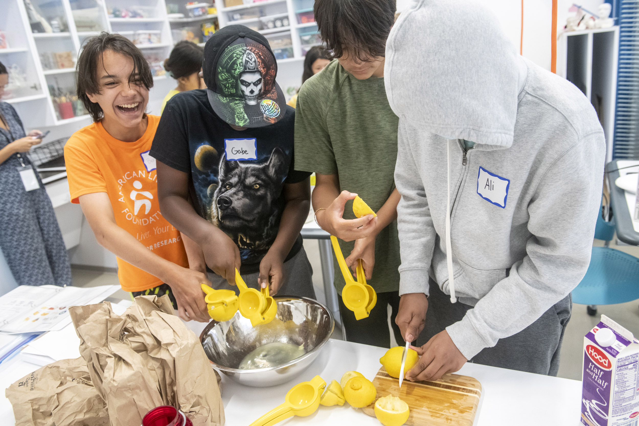 Students squeeze lemons to produce juice.