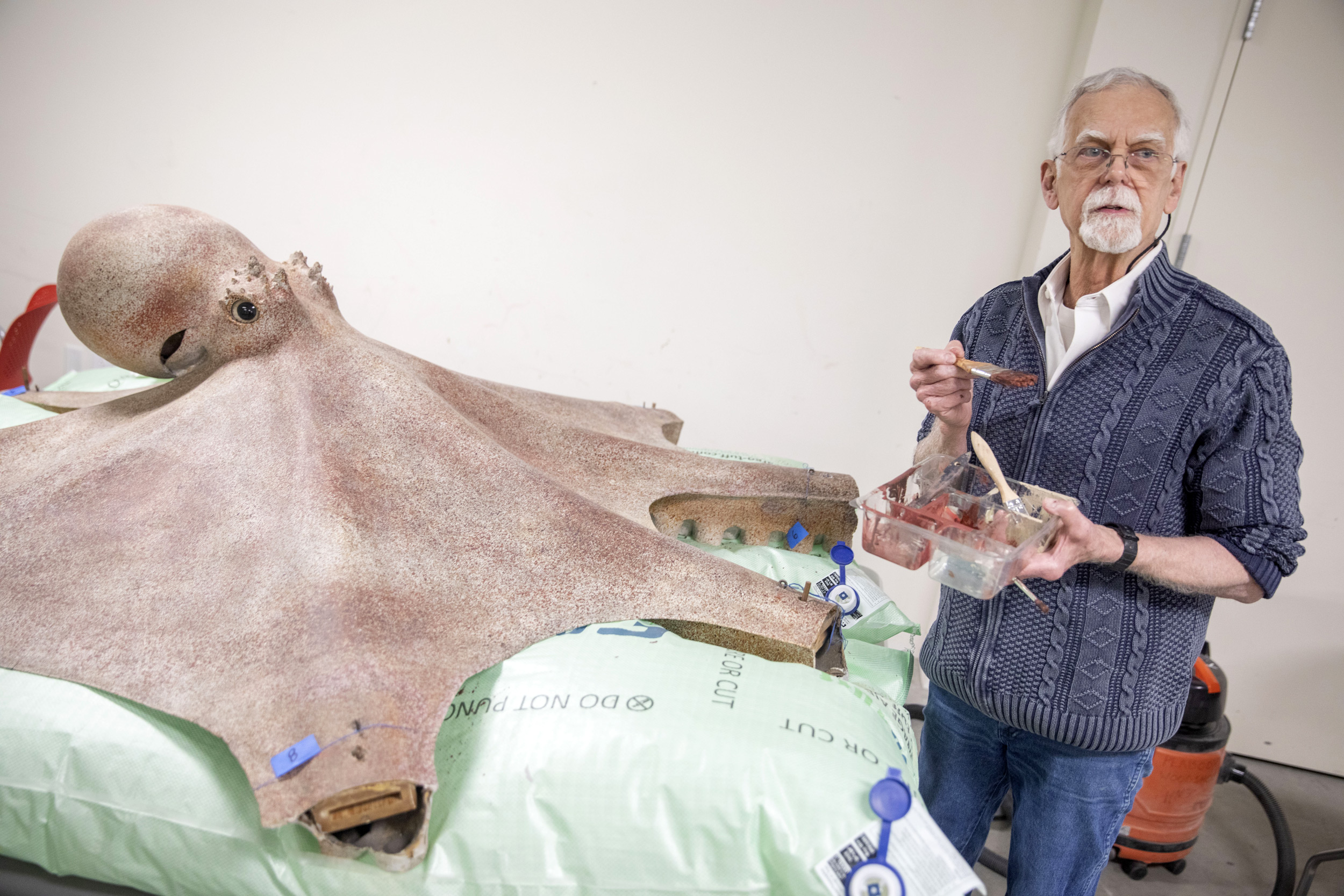 Terry Chase paints a life-sized model of a giant Pacific octopus .