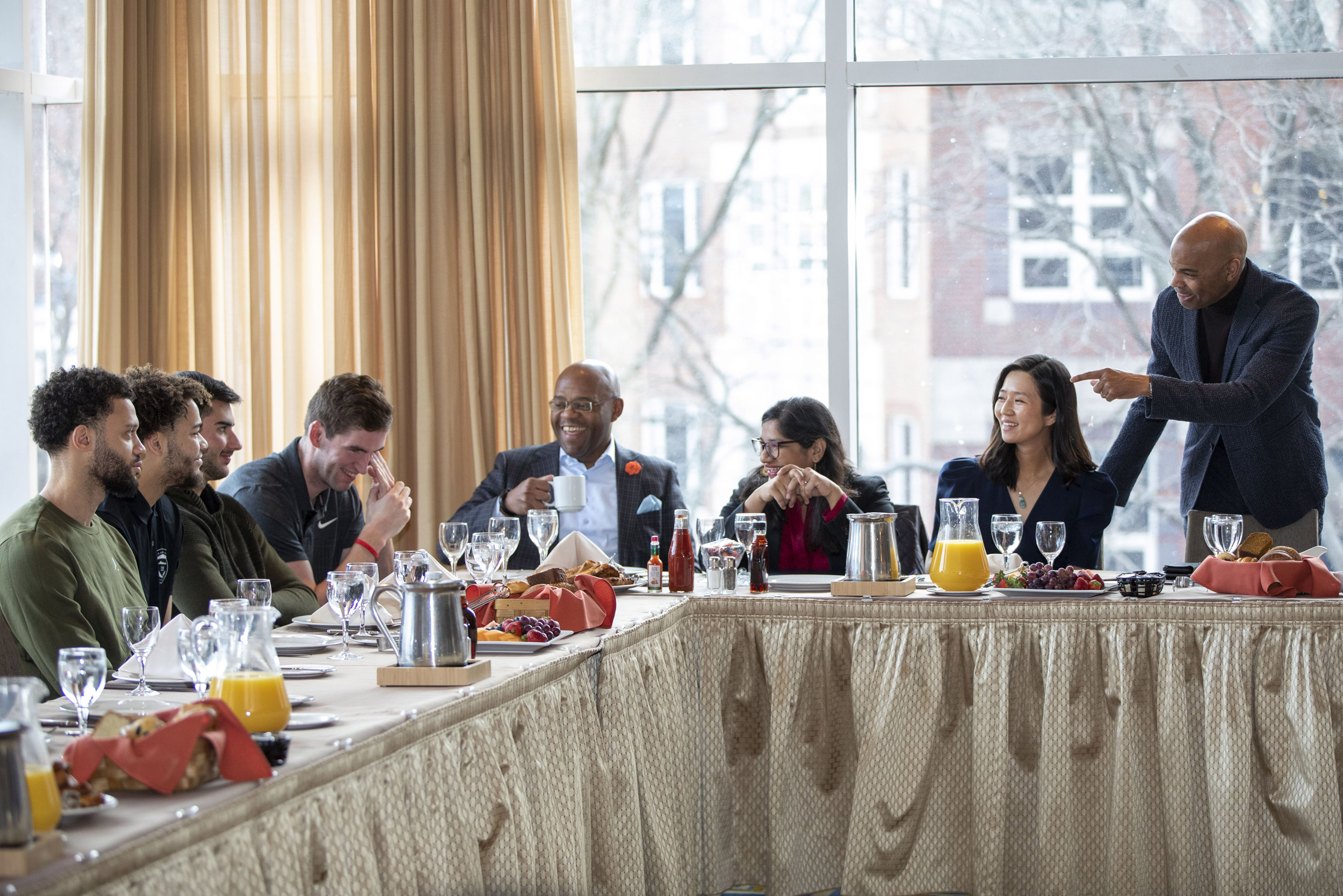 Tommy Amaker, Sumbul Siddiqui, Michelle Wy and members of Harvard's men's basketball team.