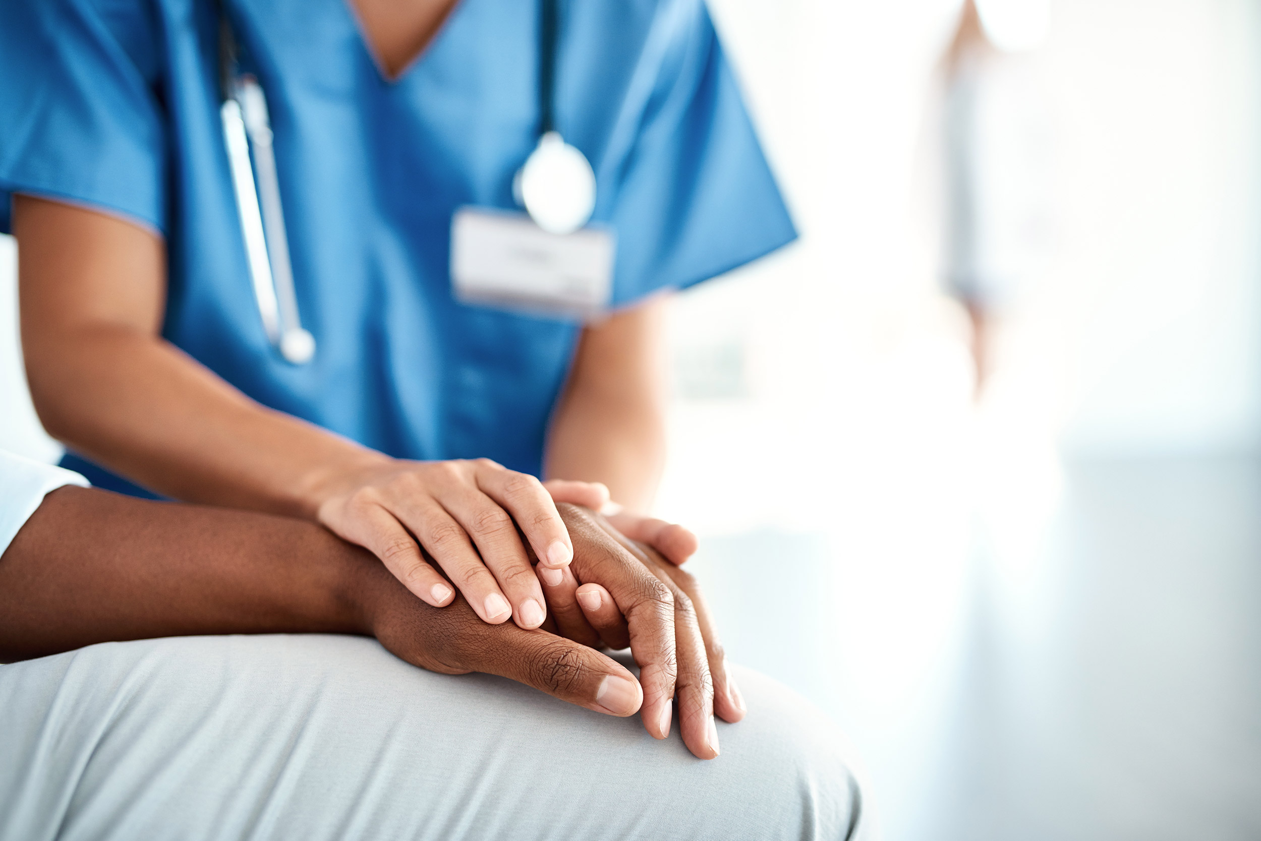 Doctor holds patient's hand.