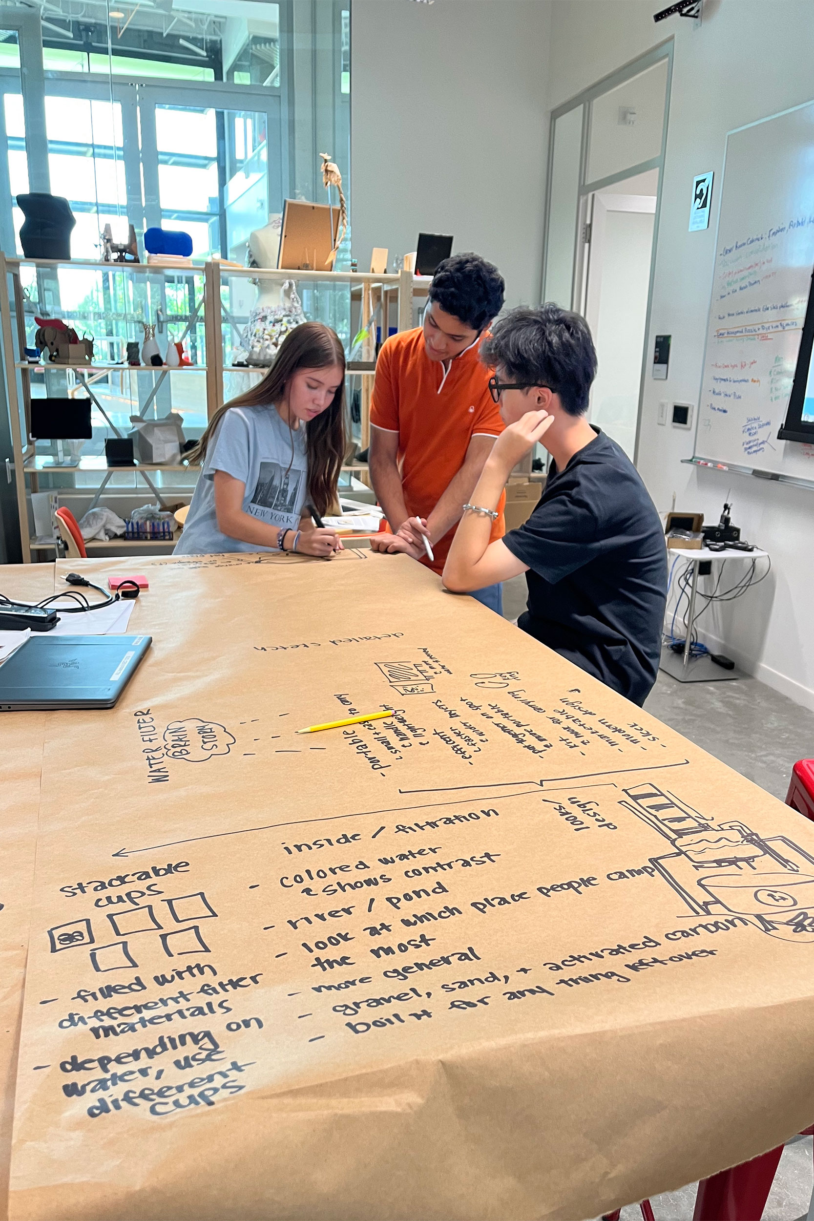 Students designing an early prototype for their water filtration system in the REEF Makerspace.