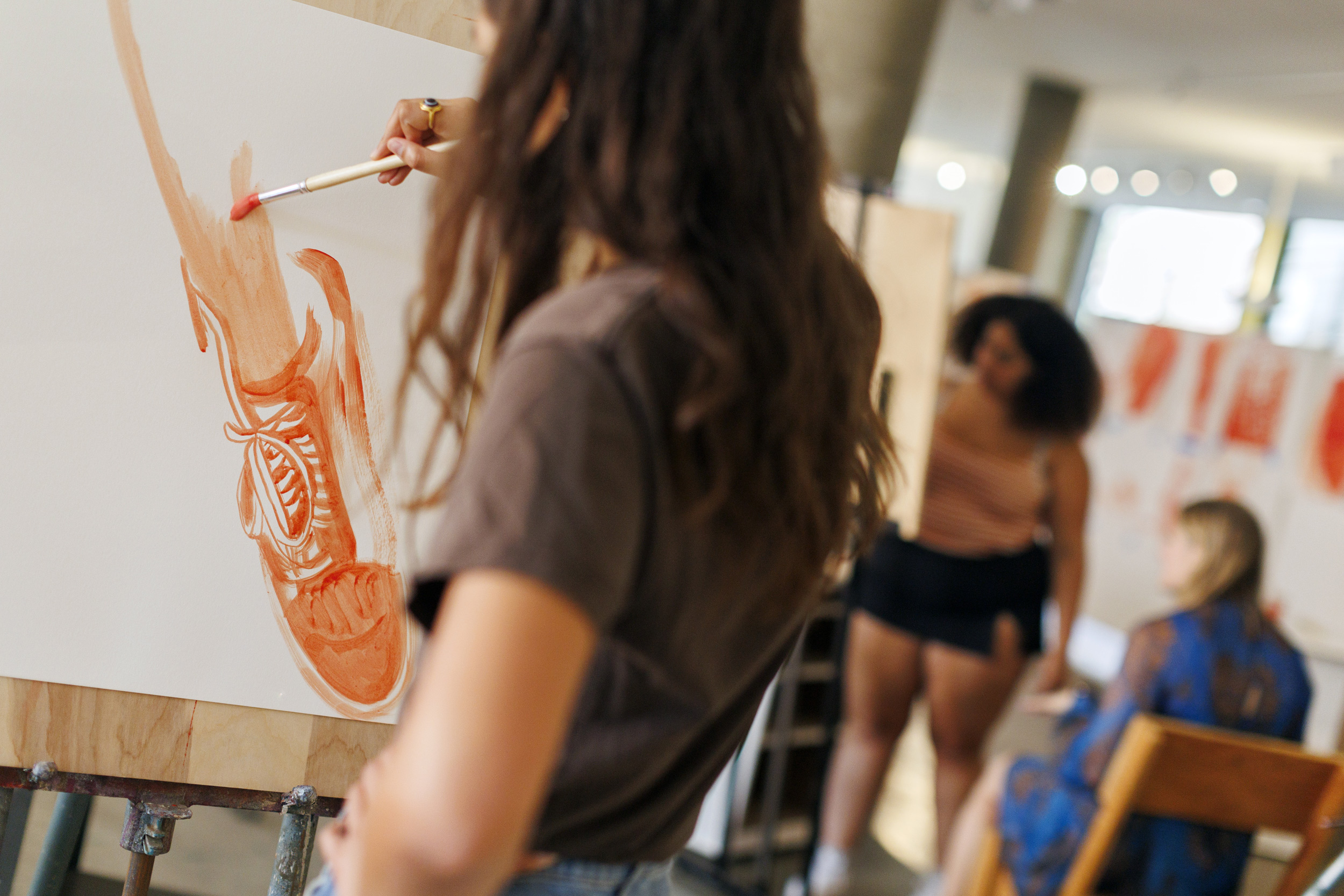 A student paints a “shoe portrait” as an introductory activity for the class “Thinking With Your Hand: Intermediate Painting.”