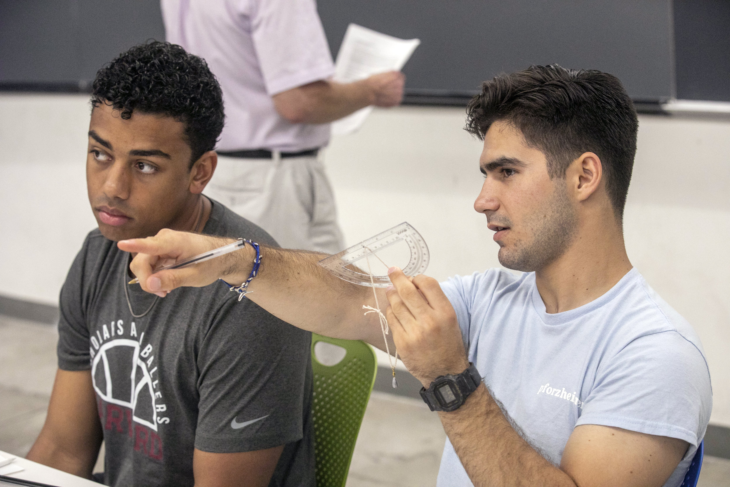 Mykalyster Homberg ’24 (left) and Luis Fernando Esteva Sueiro ’24 get acquainted with some of the tools they will be learning about in “Celestial Navigation.”