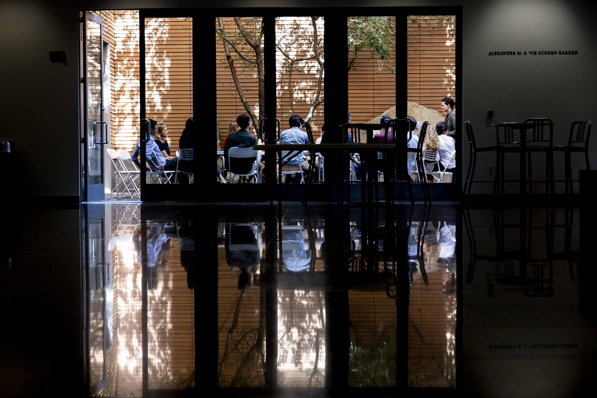 Students and faculty participate in conversation in the garden at the Center for Government and International Studies.